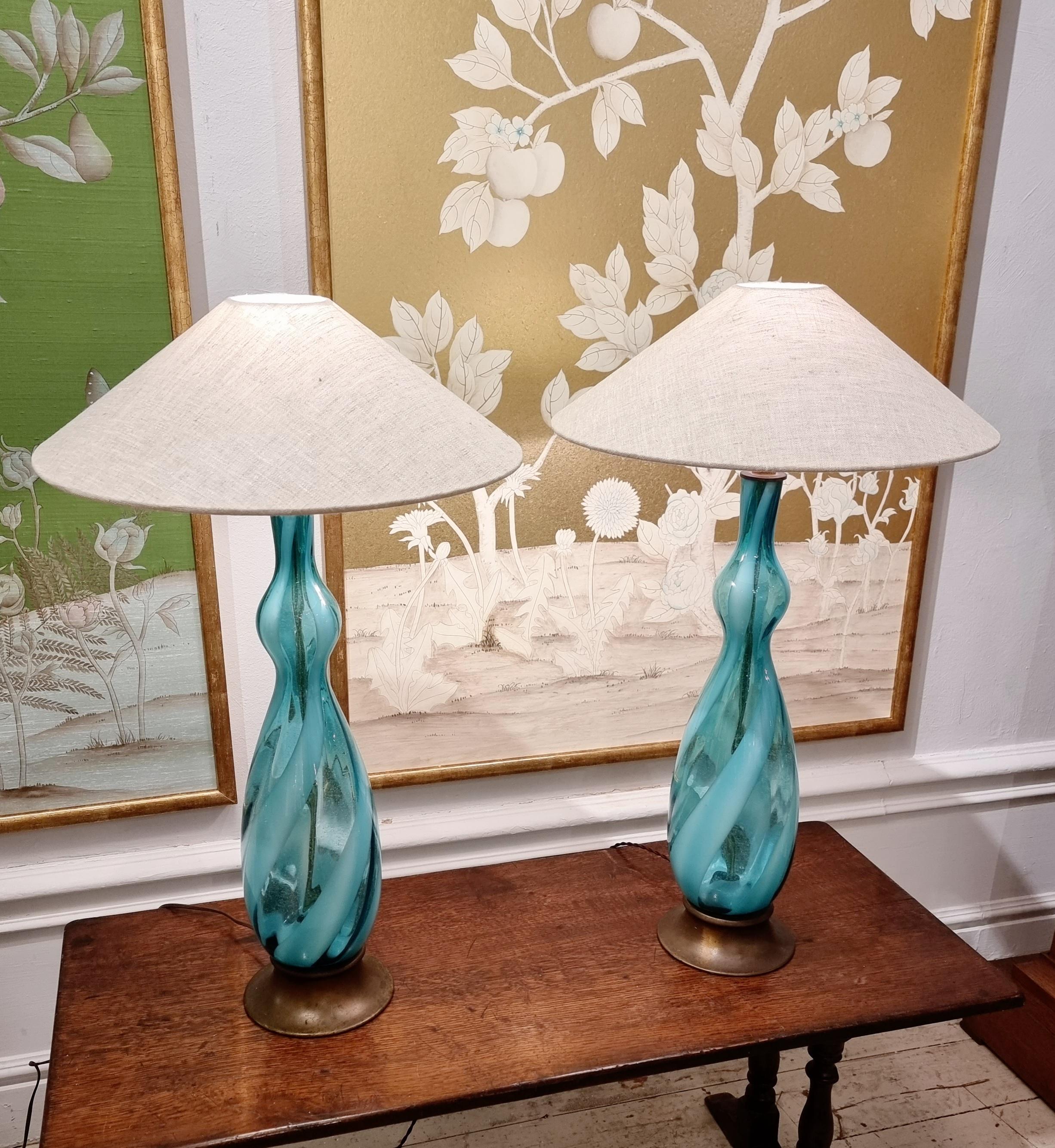 A pair of rare large Murano table lamps in blue striped glass and metal base. 
Italy, mid-1900s. Re-wired with beautiful brown fabric cord, which matches the metal base. 

Handmade shades in linen by swedish maker Din Lampa are included. 

In good