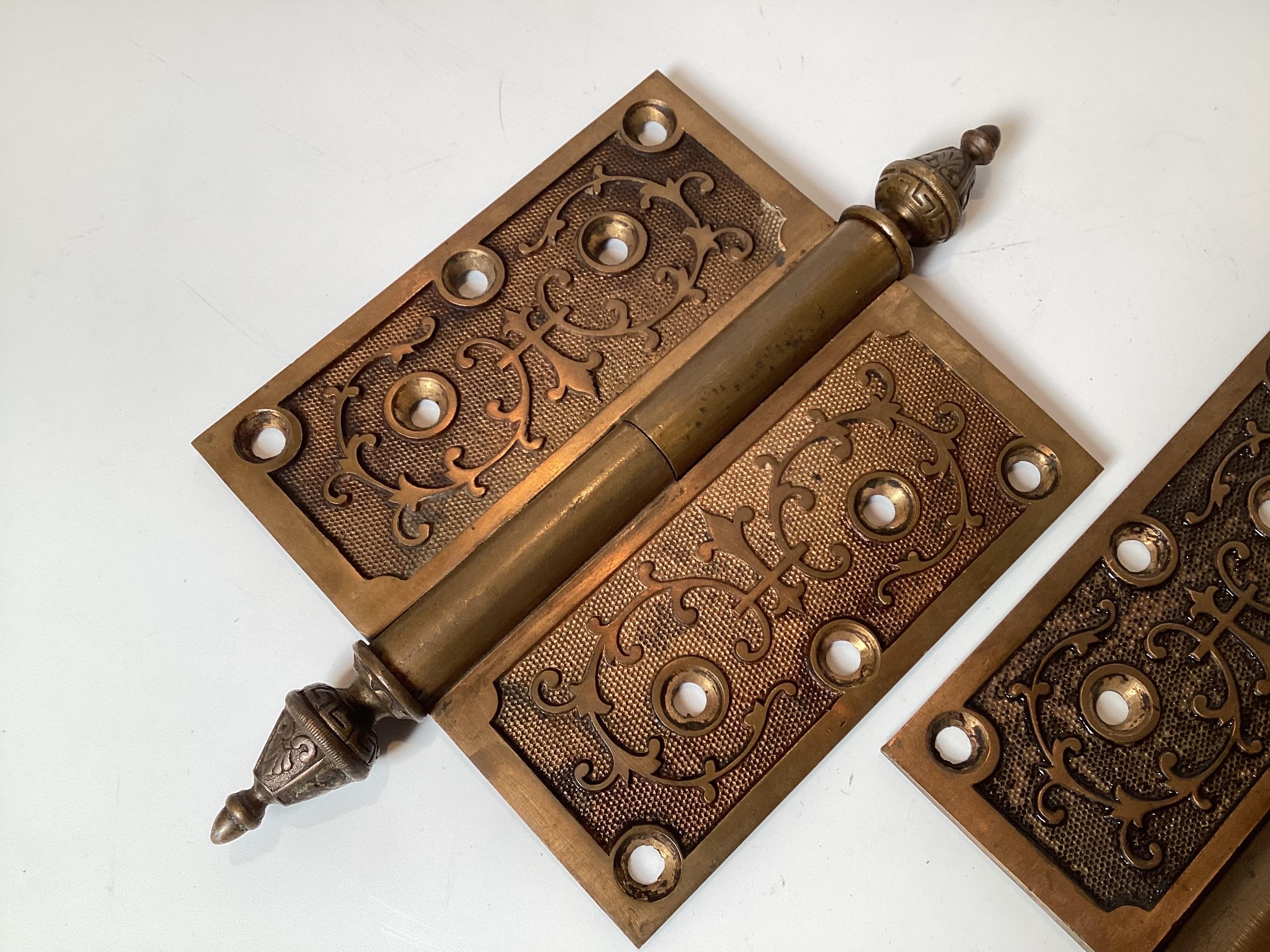 A pair of large cast bronze Victorian hinges. The hinges with pointed finials and a cast design on the surface.