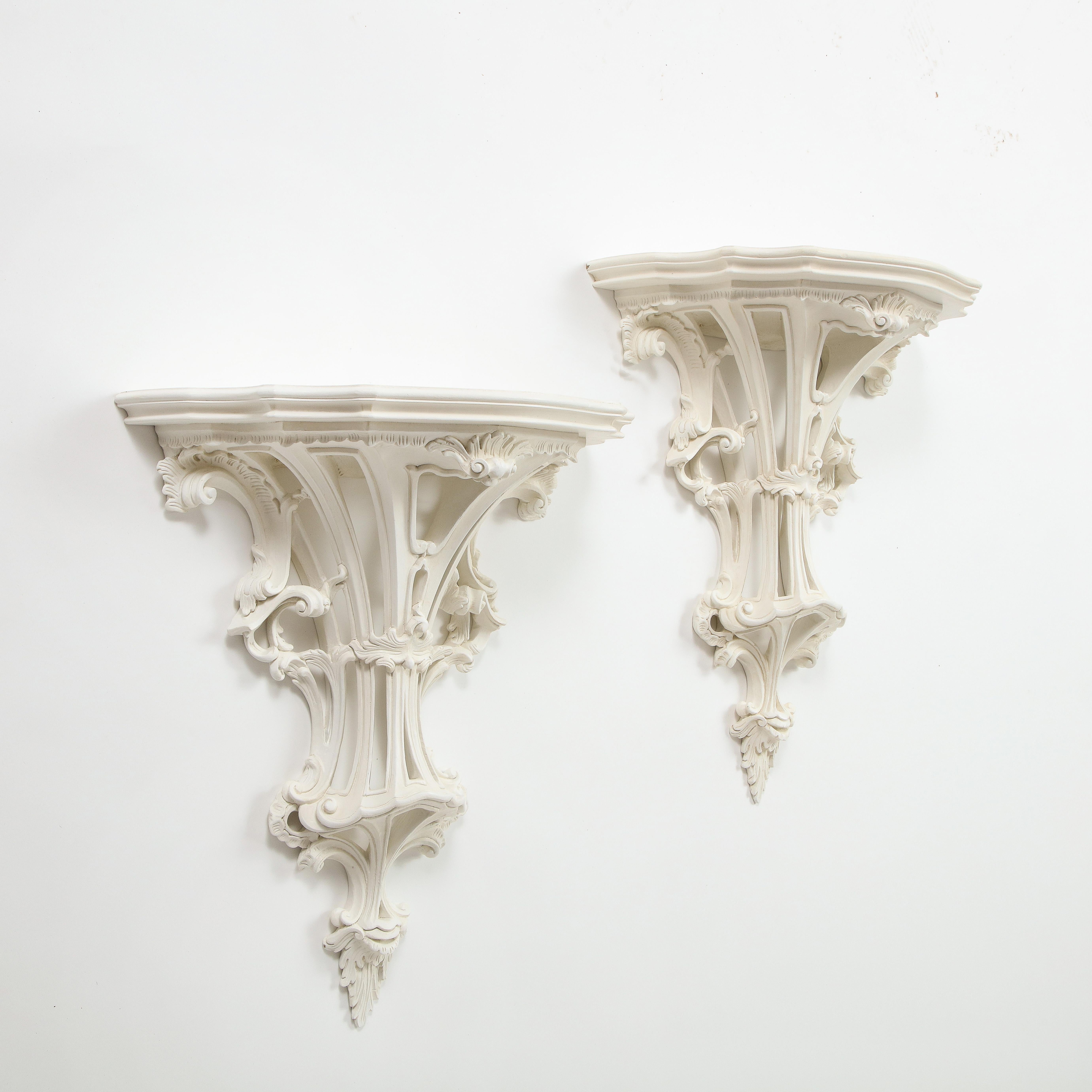 Each with shaped shelf over a tapering base pierced and elaborately carved with foliate C-scrolls and rocaille decoration.

Collection of Mario Buatta, New York, NY.