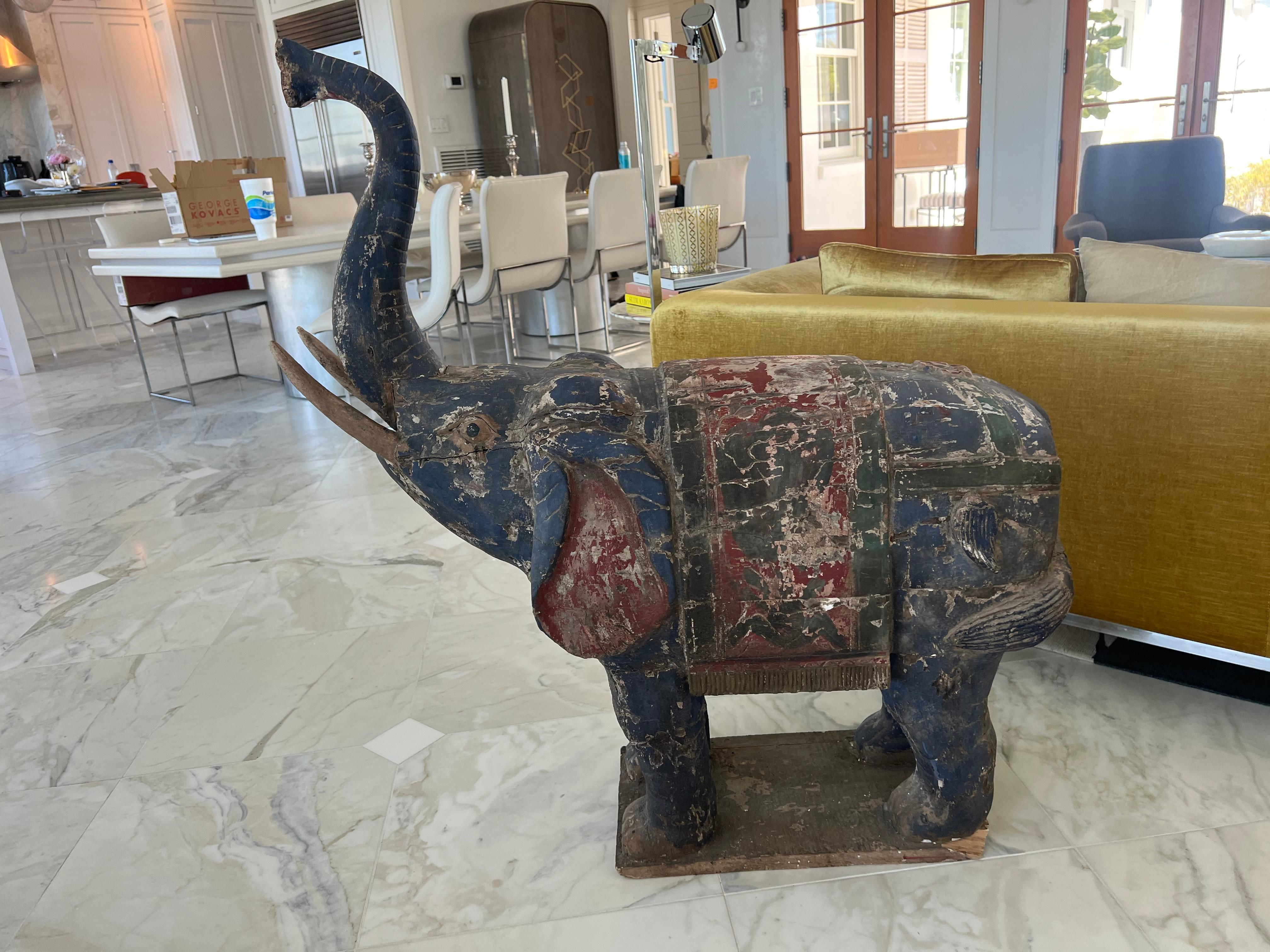 A fantastic pair of large polychrome painted Thai wood l. Trunks up for good luck! They are ever so slightly different in size because they are hand made. Excellent craftsmanship. The details on these guys are really pretty. Wear consistent with age.