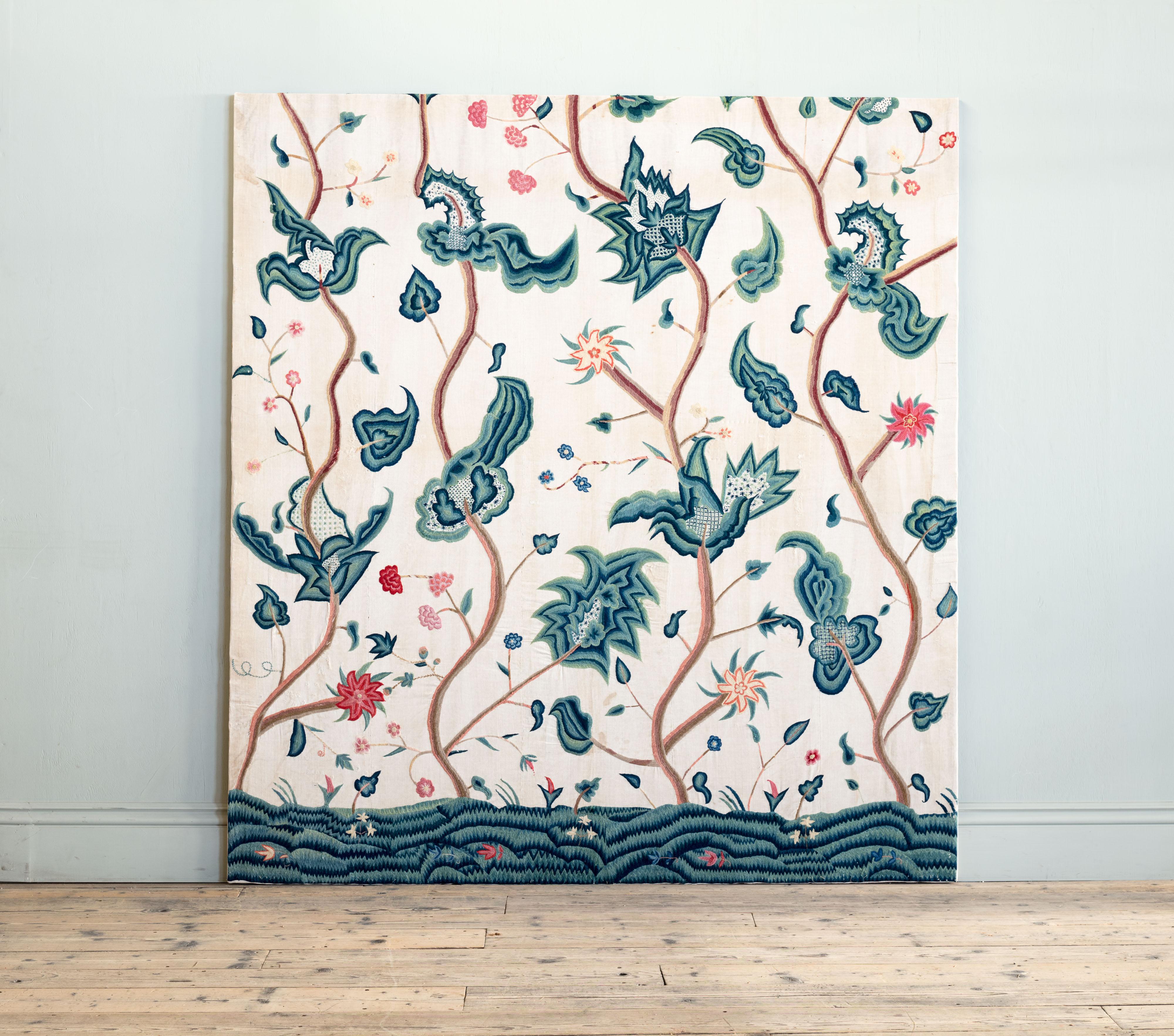 On twilled linen ground, with large scale stylised leafy and blossoming vines, embroidered in worsted wool coloured stitching. Backed on wooden stretchers.