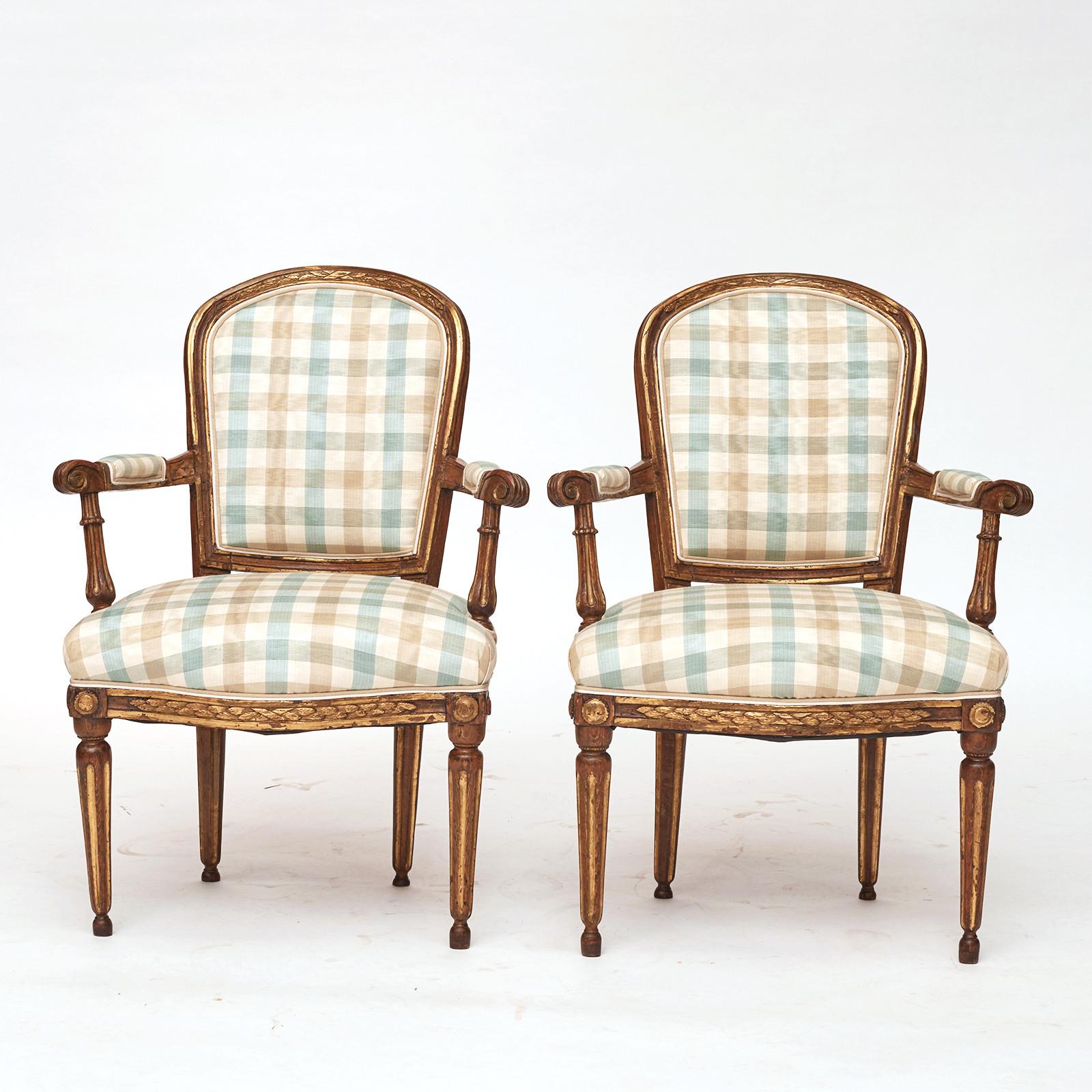 A pair of Danish Louis XVI giltwood open armchairs, late 18th century, with a arched upholstered backrest, straight armrests, upholstered seat raised on turned fluted and tapered legs. 
Wonderful giltwood patina. 
New upholstery with Fabric 'Moire'