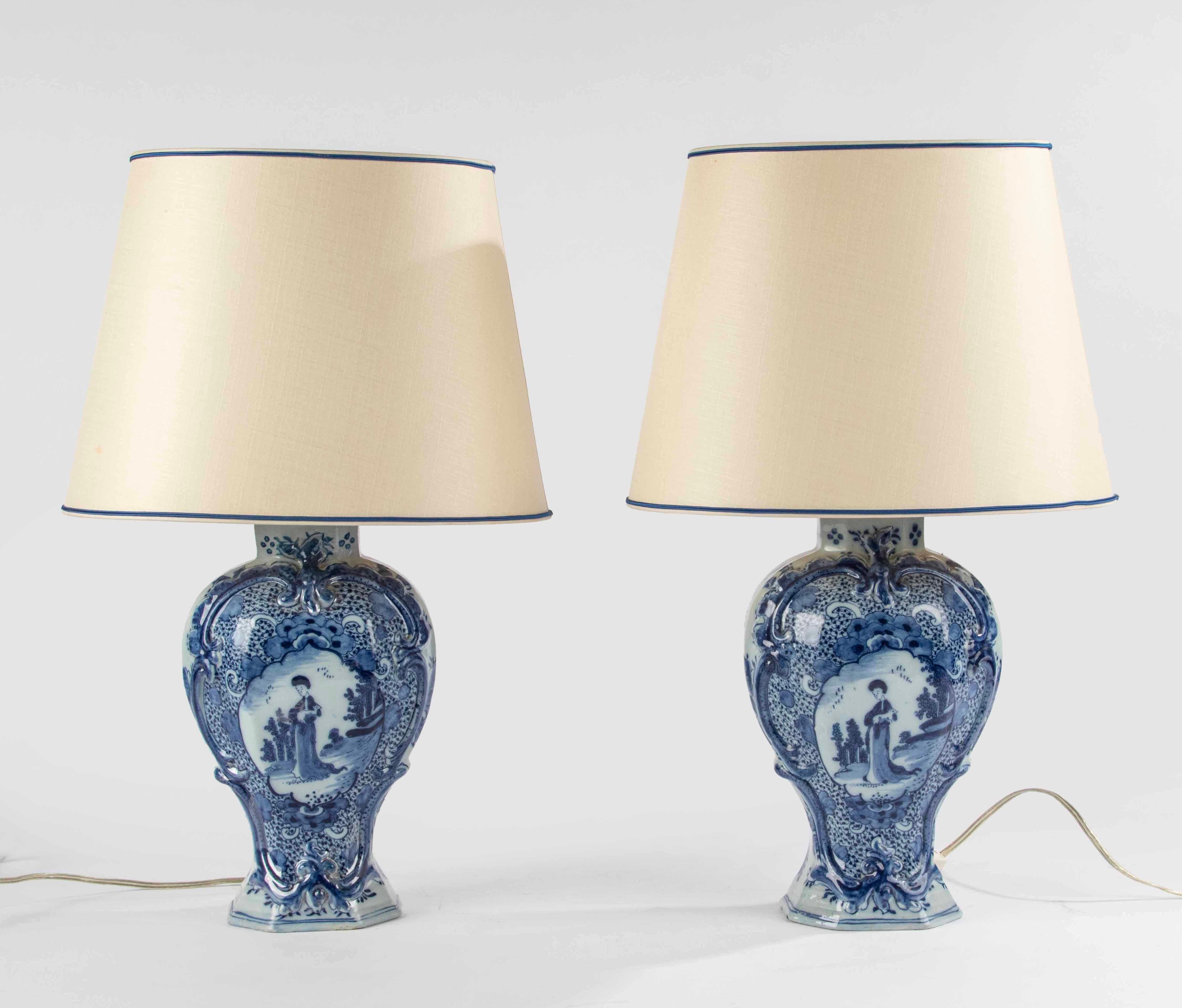 Ein bezauberndes Paar blau-weißer Delfter Keramikvasen aus dem späten 18. Jahrhundert, die kürzlich als Lampen montiert wurden. 
Die Vasen sind wunderschön verziert mit Blumenornamenten im typischen Delfter Stil und einer Szene mit einer Frau, die