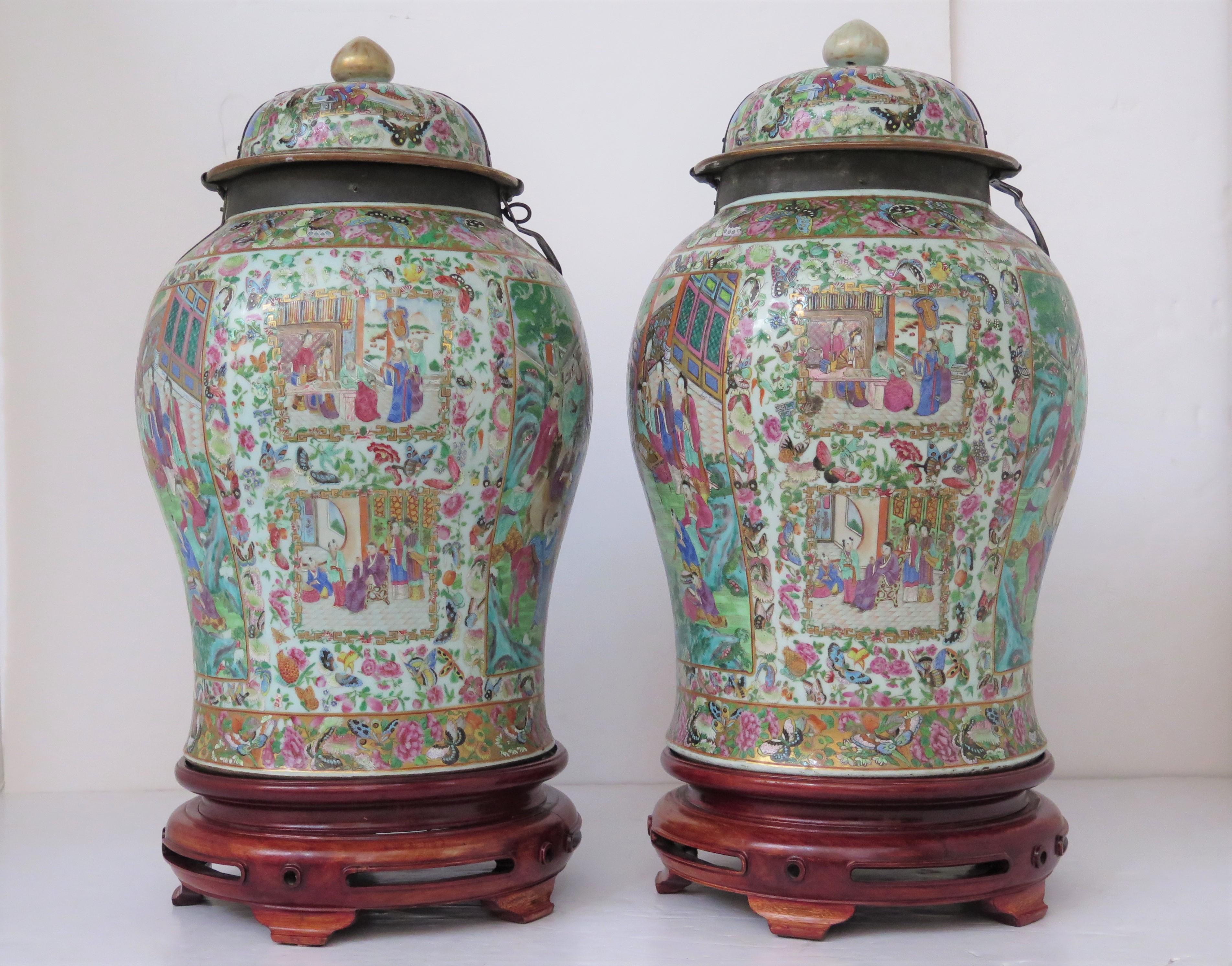 A pair of late 18th-early 19th century Chinese beautifully painted famille rose lidded jars. Very impressive with iron straps to secure and lock the lids. Jars are raised on 5