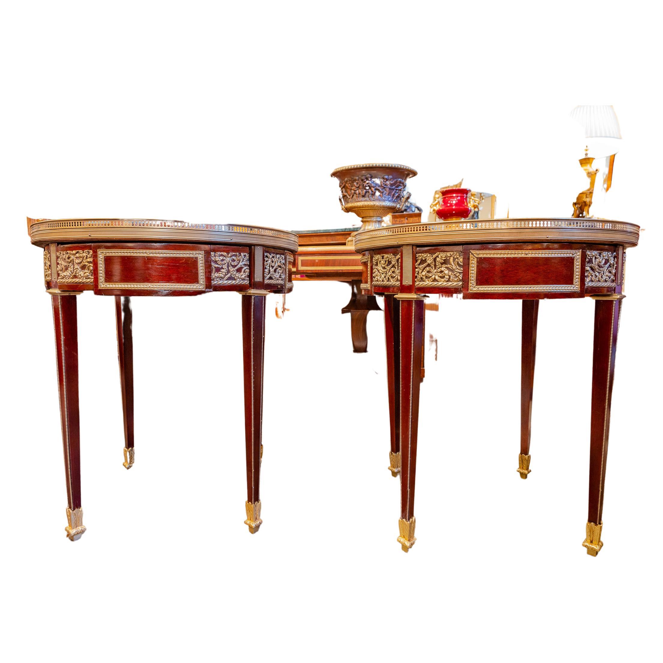 A fine pair of late 19th century French Louis XVI mahogany and gilt bronze gueridon tables. Carrera marble tops with a gallery. Single drawers.