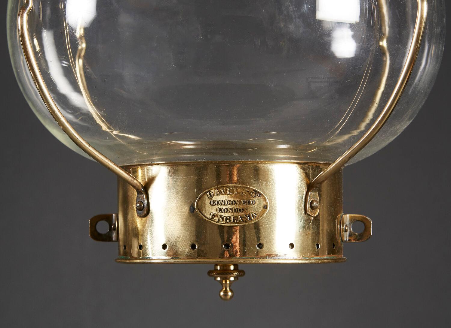 A pair of late nineteenth century brass and glass campaign hanging lanterns, of bulbous from, with brass pagoda lids and loop handles to the tops, the bases stamped with a makers mark reading DAVEY & CO, LONDON LTD, LONDON ENGLAND. 

Currently wired