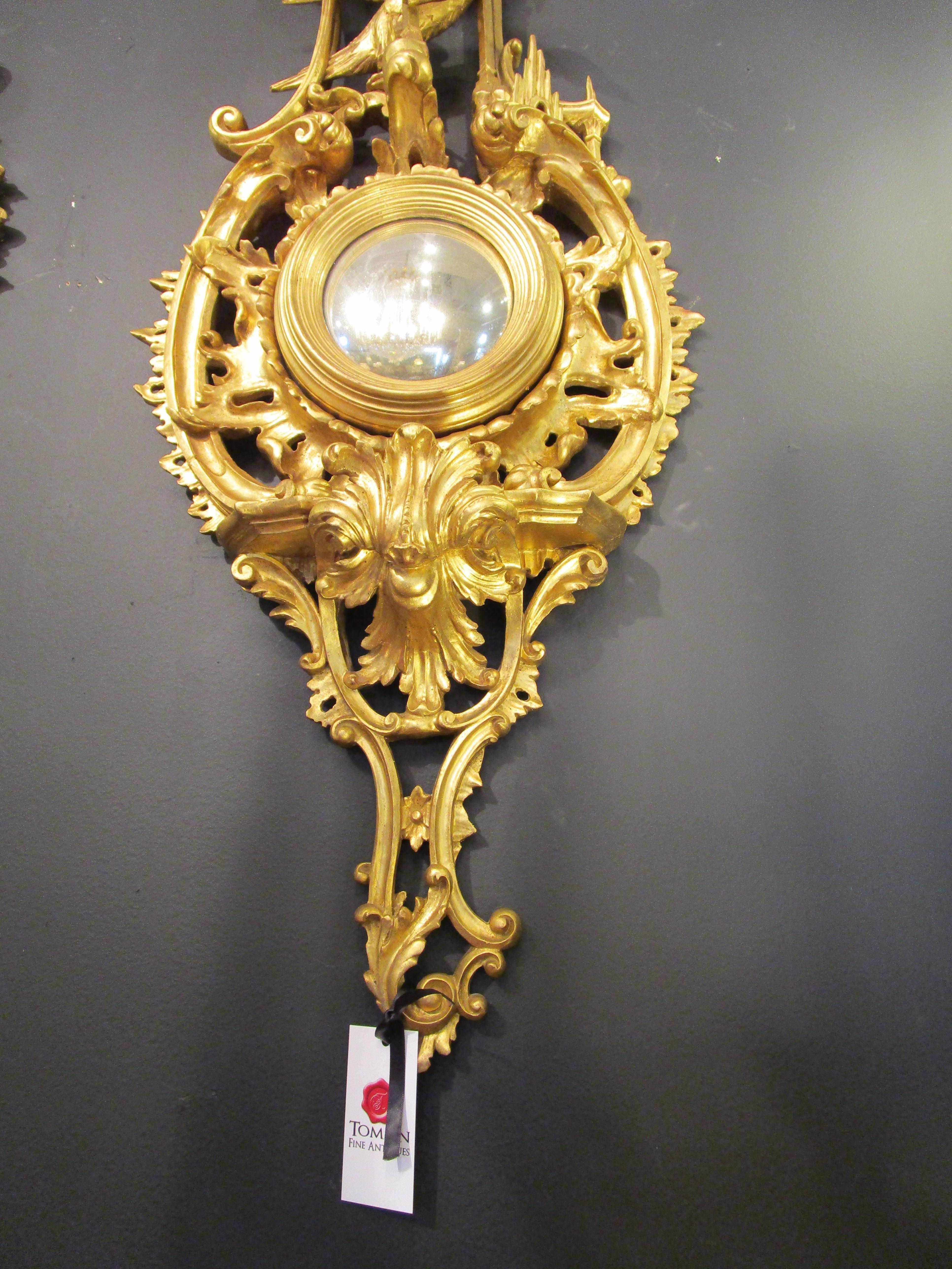 A fine pair of late 19th century Chinoiserie hand carved and gilt convex mirrors. Ho Ho bird details.