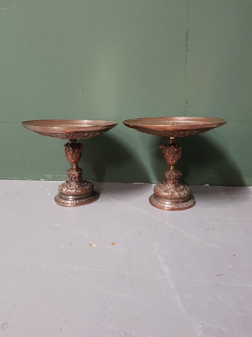 A pair of antique copper plated pewter tazzas with allegorical representations of gods, mythical creatures etc and around Latin words, both wear consistent by age and use and from the late 19th century.

The measurements are,
Depth 18.5cm/ 7.2