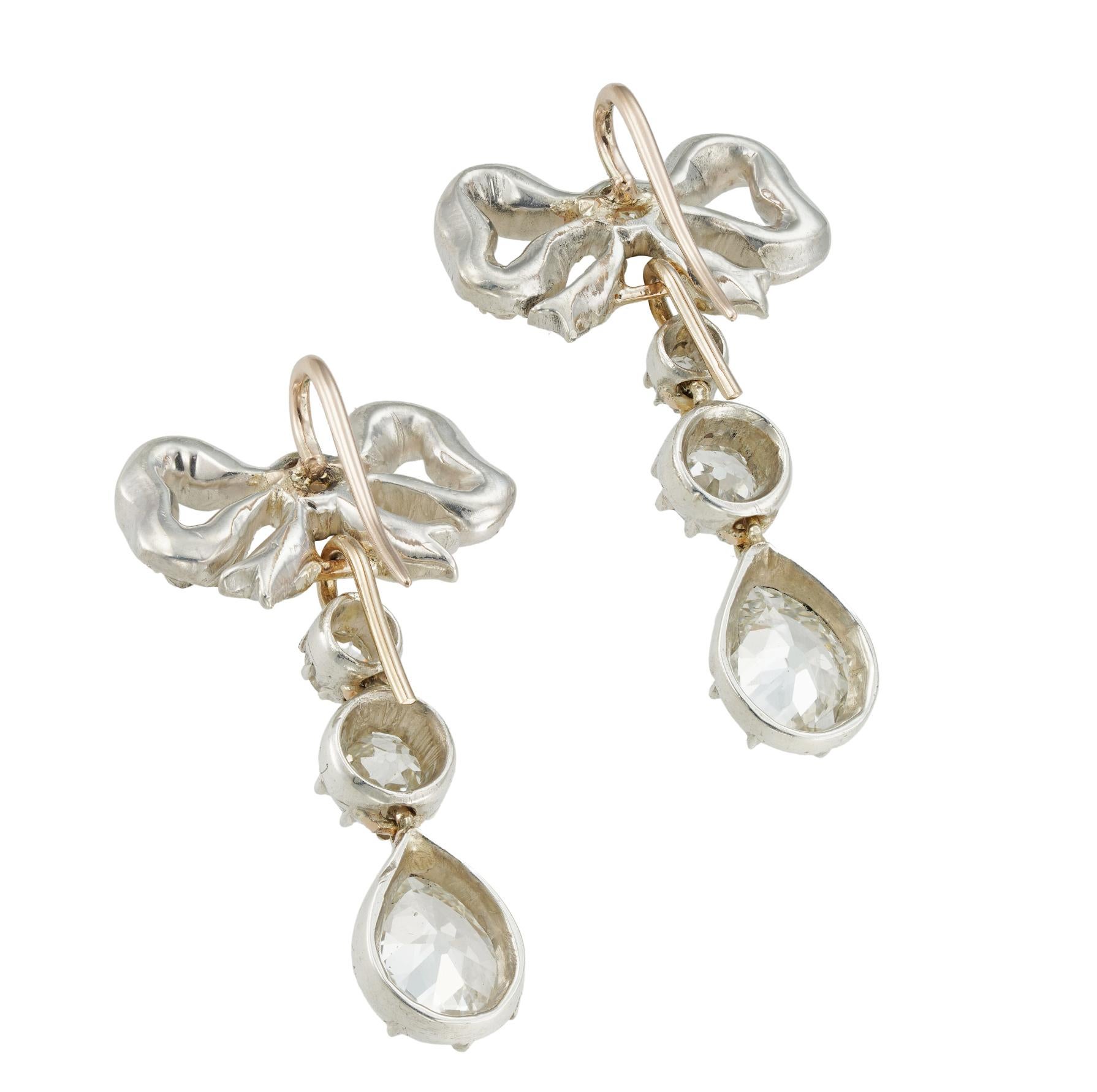 A pair of late 19th century diamond-set bow earrings, each bow set with twenty-one small old mine-cut diamonds, each suspending a detachable early Victorian drop with two old-cut diamonds weighing approximately 0.70 carats and an old pear-shaped
