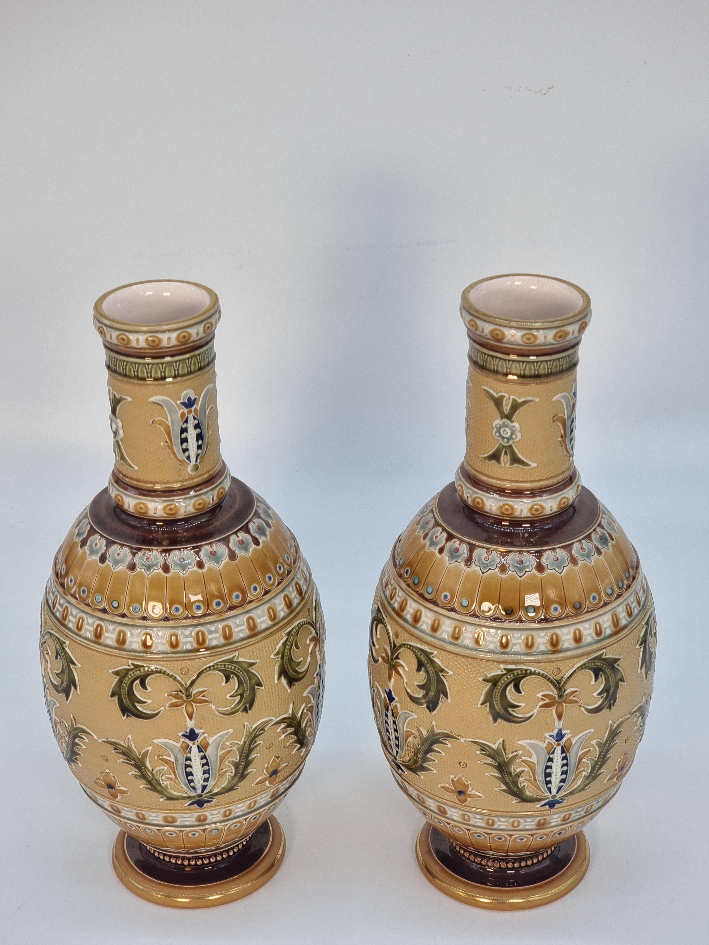 This finely detailed and stunning pair of German pottery vases was made at the Mettlach factory circa 1890. They were renowned for making this type of fine ware. These perfect pairs are luxuriously decorated in rich colours and gilt. Elegantly