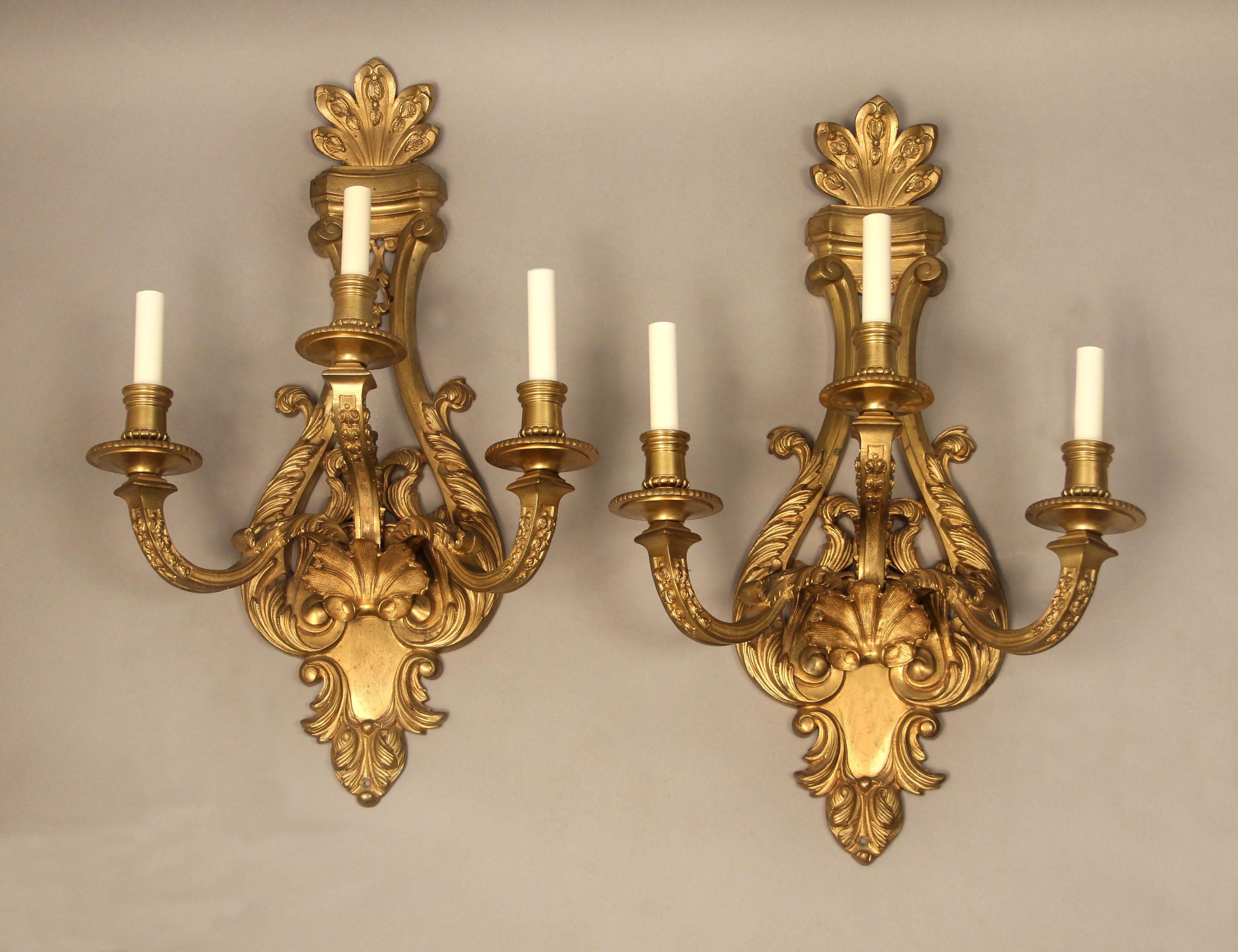 A pair of late 19th century gilt bronze three light sconces

Each backplate decorated with a shell centered below and between the three arms.