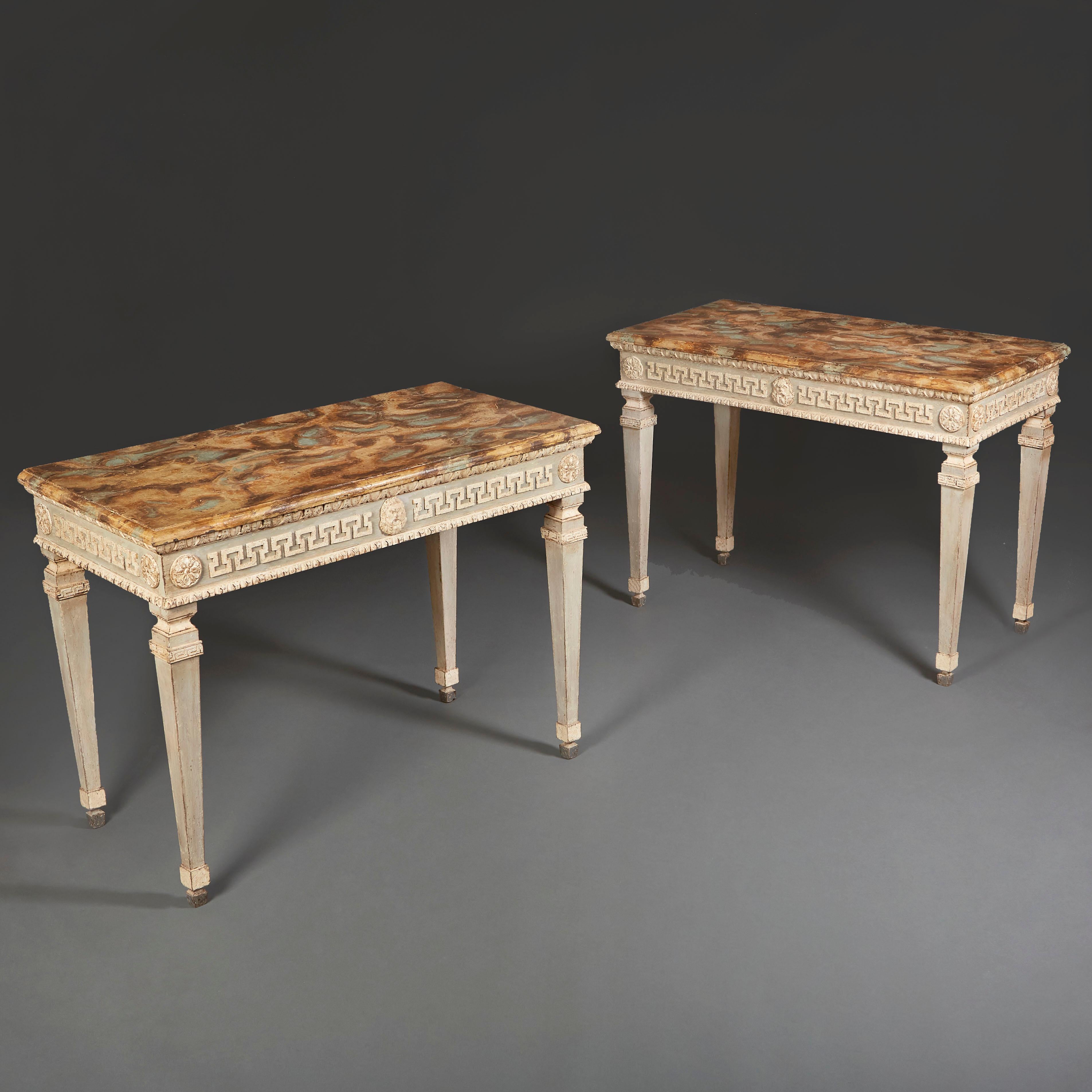 A pair of late 19th century painted console tables in the manner of William Kent, with Greek key and satyr masks to the frieze, egg and dart moulding below the painted tops, all suported on fluted, tapering legs.