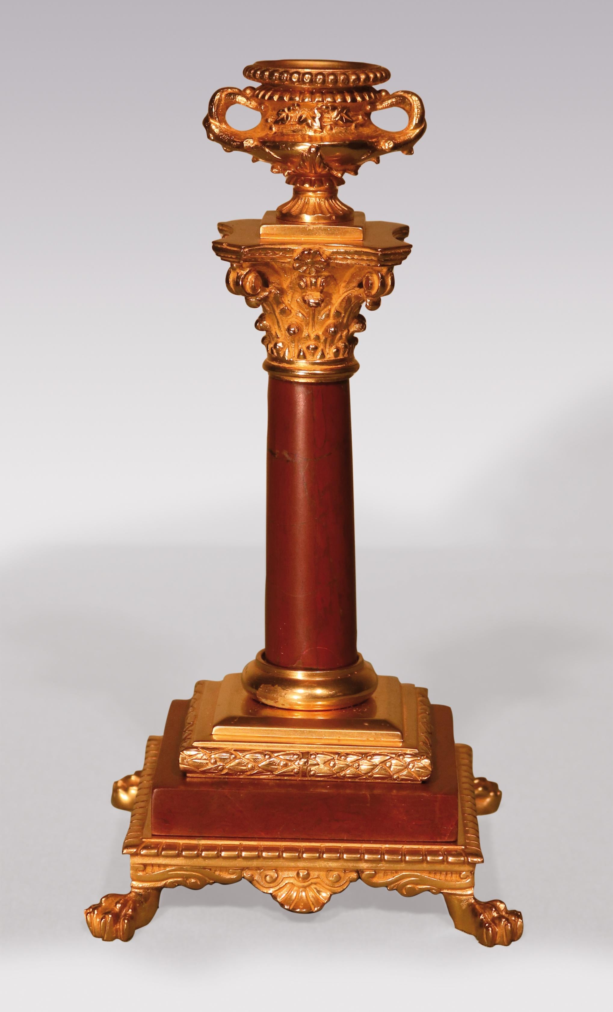Pair of late 19th century ormolu Candlesticks in the form of antico rouge Corinthian columns surmounted by stylised “Warwick” vases supported on marble plinths ending on lion’s paw feet.