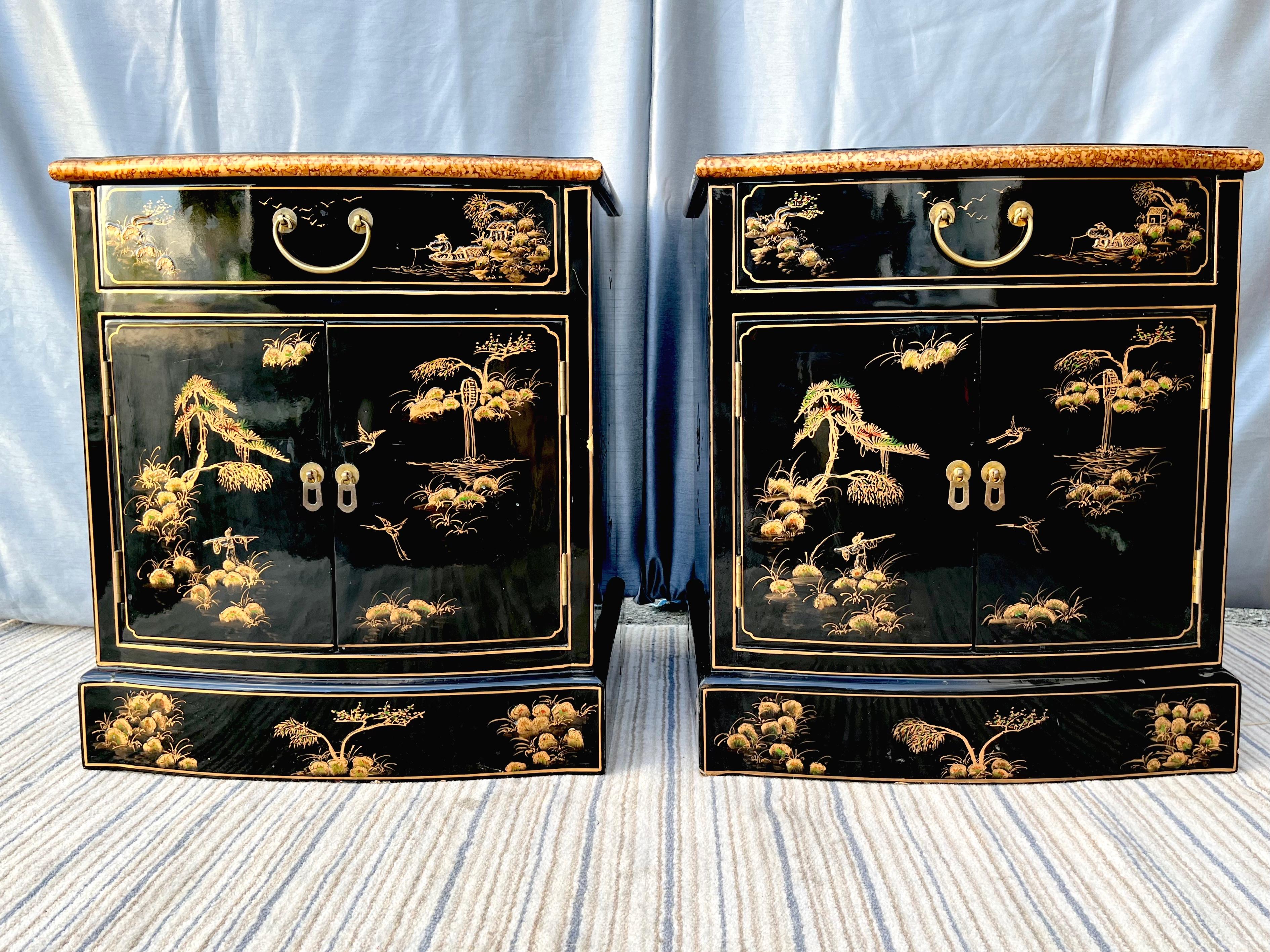 A pair of Late 20th Century Black Lacquered Chinoiserie night stands. Circa 1990s
Feature a top drawer and a two doors cabinet for extra storage with both with heavy brass hardware and a glossy black lacquered finish with hand-painted Chinese