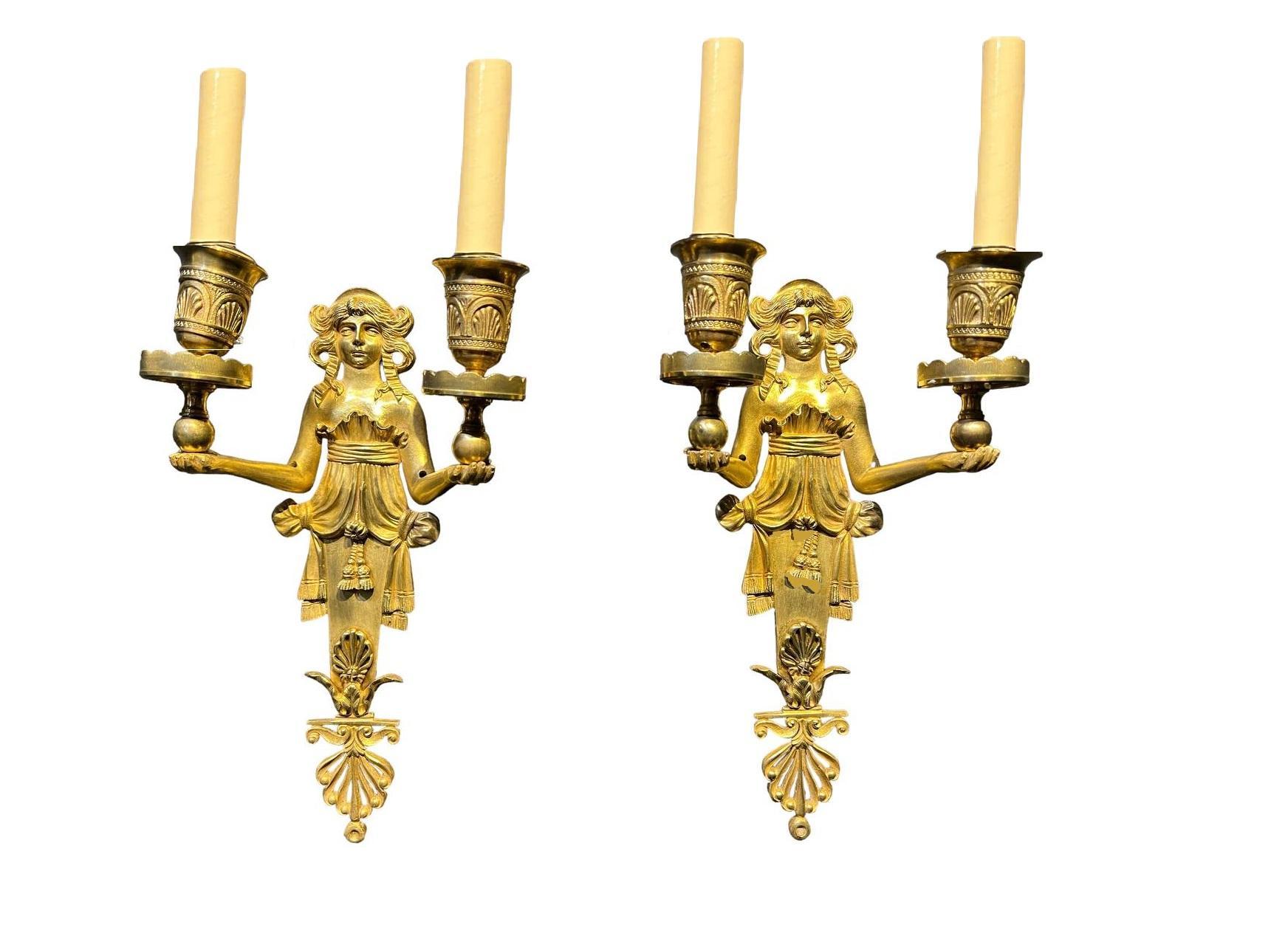 Coppia di piccole appliques in bronzo dorato stile Impero francese della fine del XIX secolo. Un design insolito con donna che tiene in mano delle palline