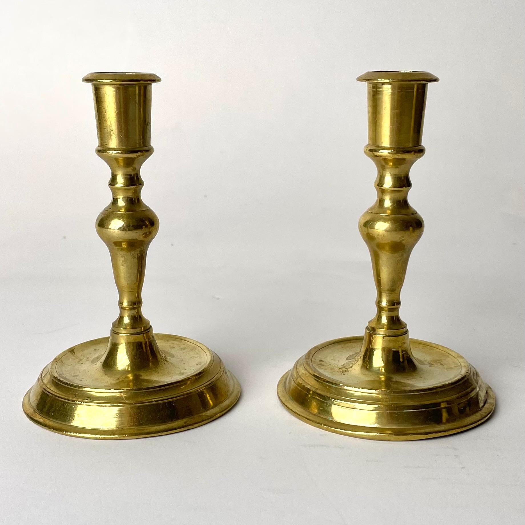A Pair of Late Baroque Candlesticks, Brass. Made during the early 18th Century.

A beautiful pair of late baroque candlesticks, in a warm tone of brass. In the Late Baroque of the early 18th century, these candlesticks are of a refined and elegant