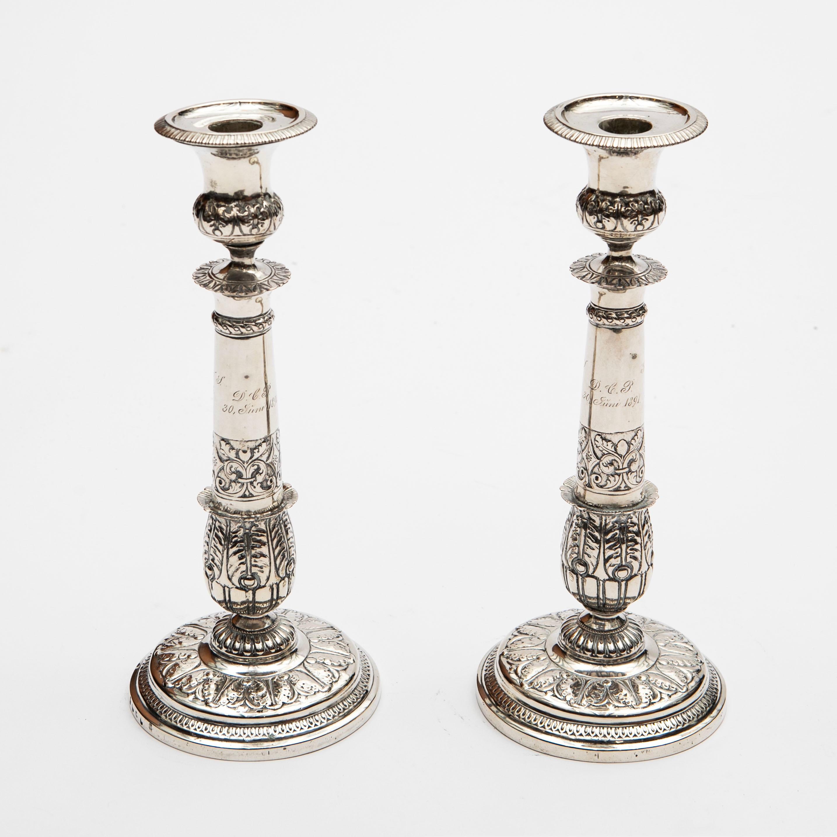 Coppia di candelieri in argento del tardo Impero realizzati dal maestro argentiere Caspar Julius Worm.
Creati a Copenaghen nel 1837, questi candelieri sono riccamente decorati con intricate foglie d'acanto, vasi e dettagli fleur-de-lis, incarnando