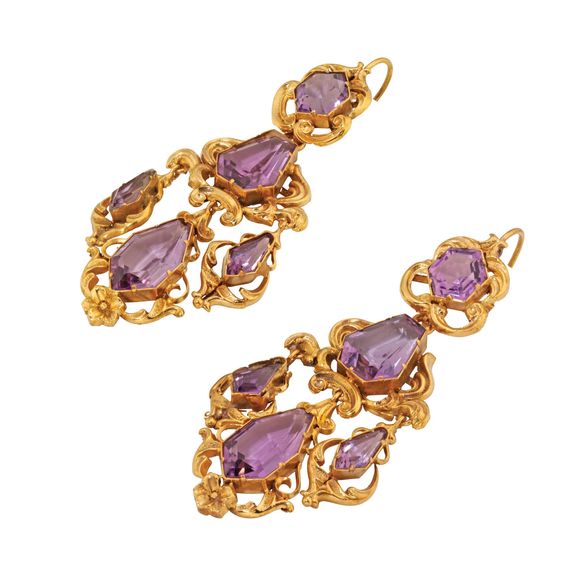 A pair of late Georgian amethyst and repousse gold scroll motif earrings, each drop comprising a hexagonal-shaped faceted amethyst to the top, a kite shaped faceted amethyst to the centre with three graduated amethyst drops beneath weighing a total