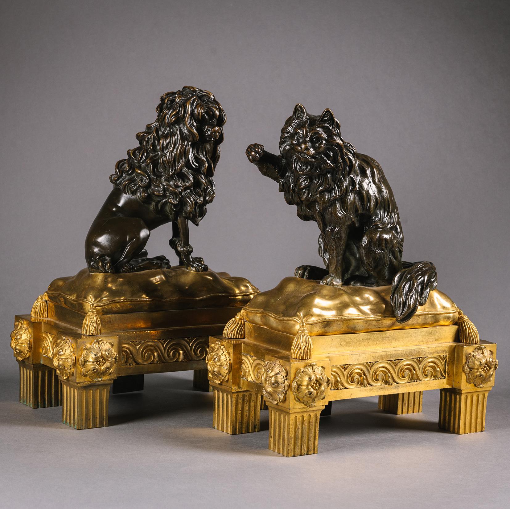 A Pair Of Late Louis XV Period Gilt And Patinated Bronze Figural Chenets, Attributed to Jacques and Philippe Caffieri.

Modelled as a dog and cat, each seated on a tasselled cushion atop a Goût grec base with entrelac panelled frieze and eared
