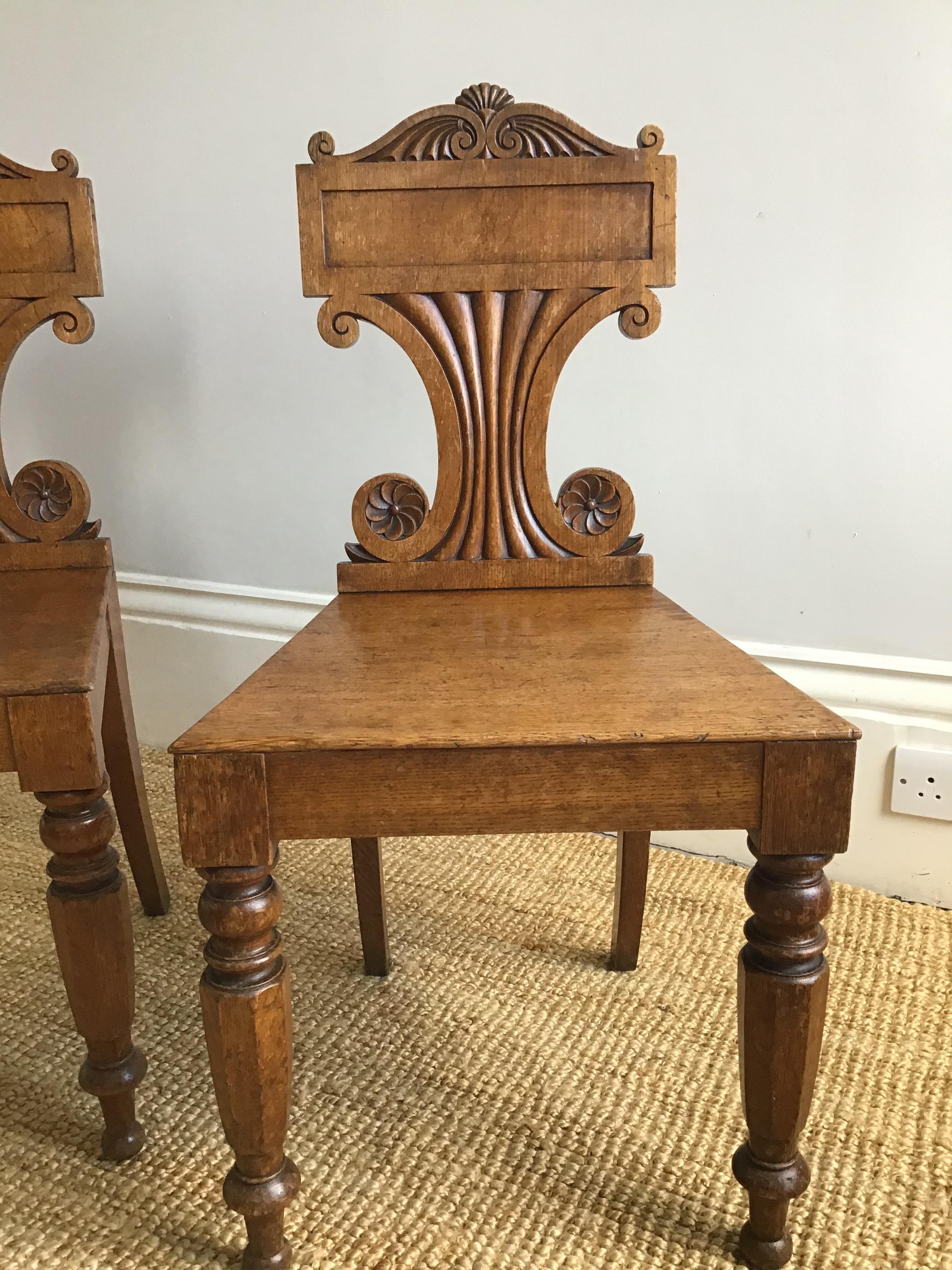 Carved Pair of Late Regency Oak Hall Chairs For Sale