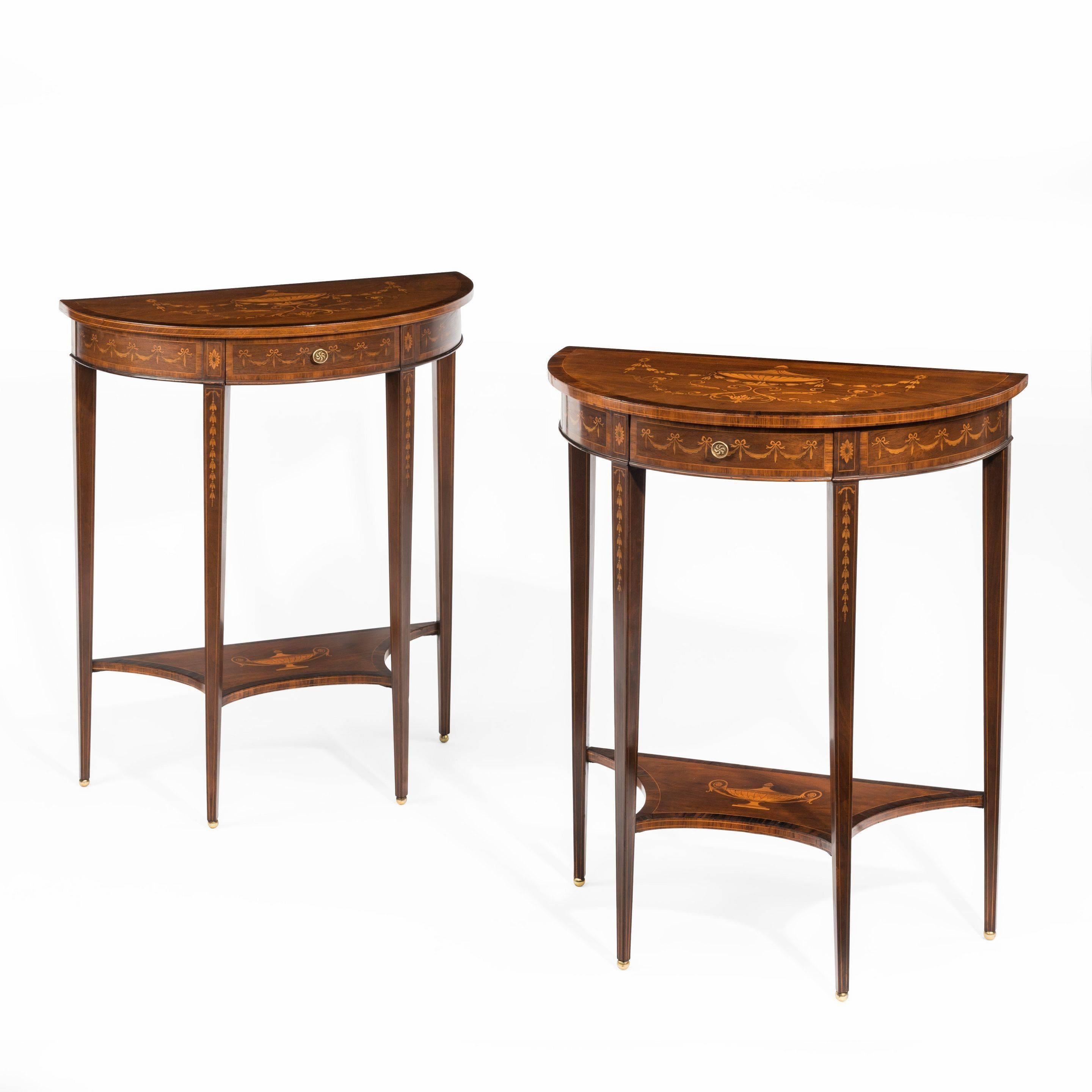 A pair of late Victorian demilune mahogany console tables, attributed to Edwards and Roberts, each of hemispherical form with a single disguised frieze drawer set upon four tapering square-section legs joined by a solid cusped stretcher, inlaid with