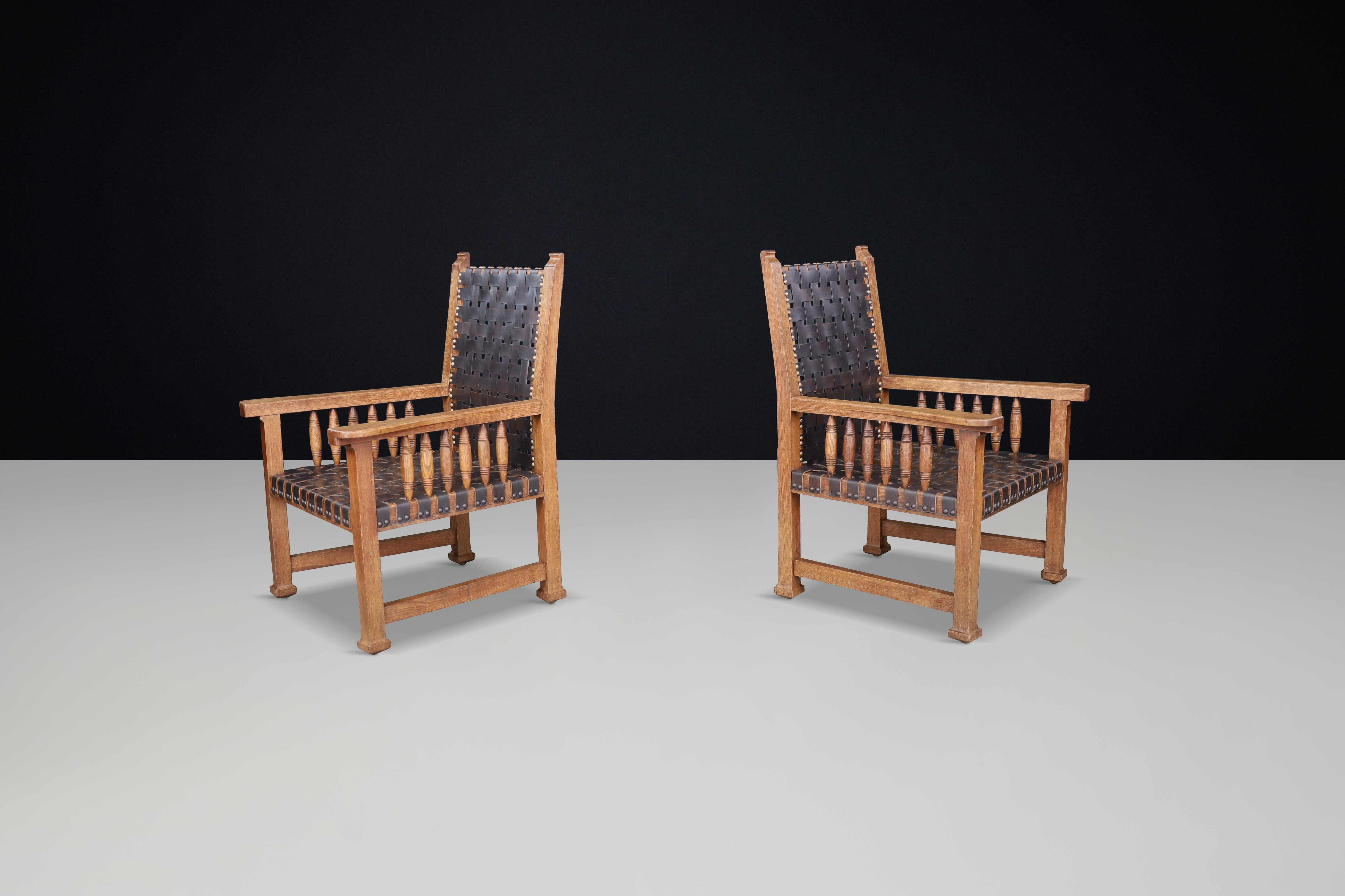 French Provincial A pair of leather and oak armchairs from France, 1950s. For Sale
