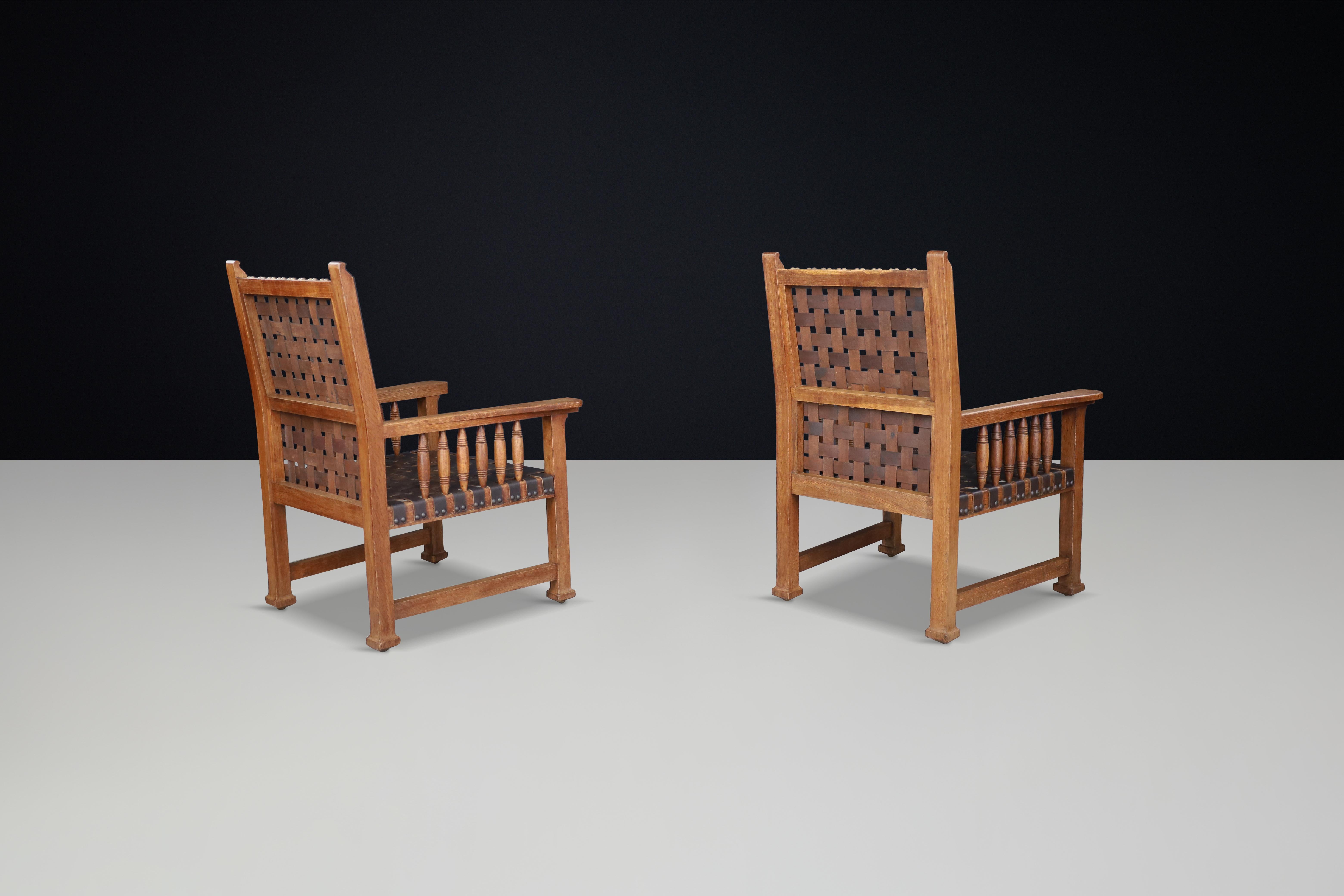 French A pair of leather and oak armchairs from France, 1950s. For Sale