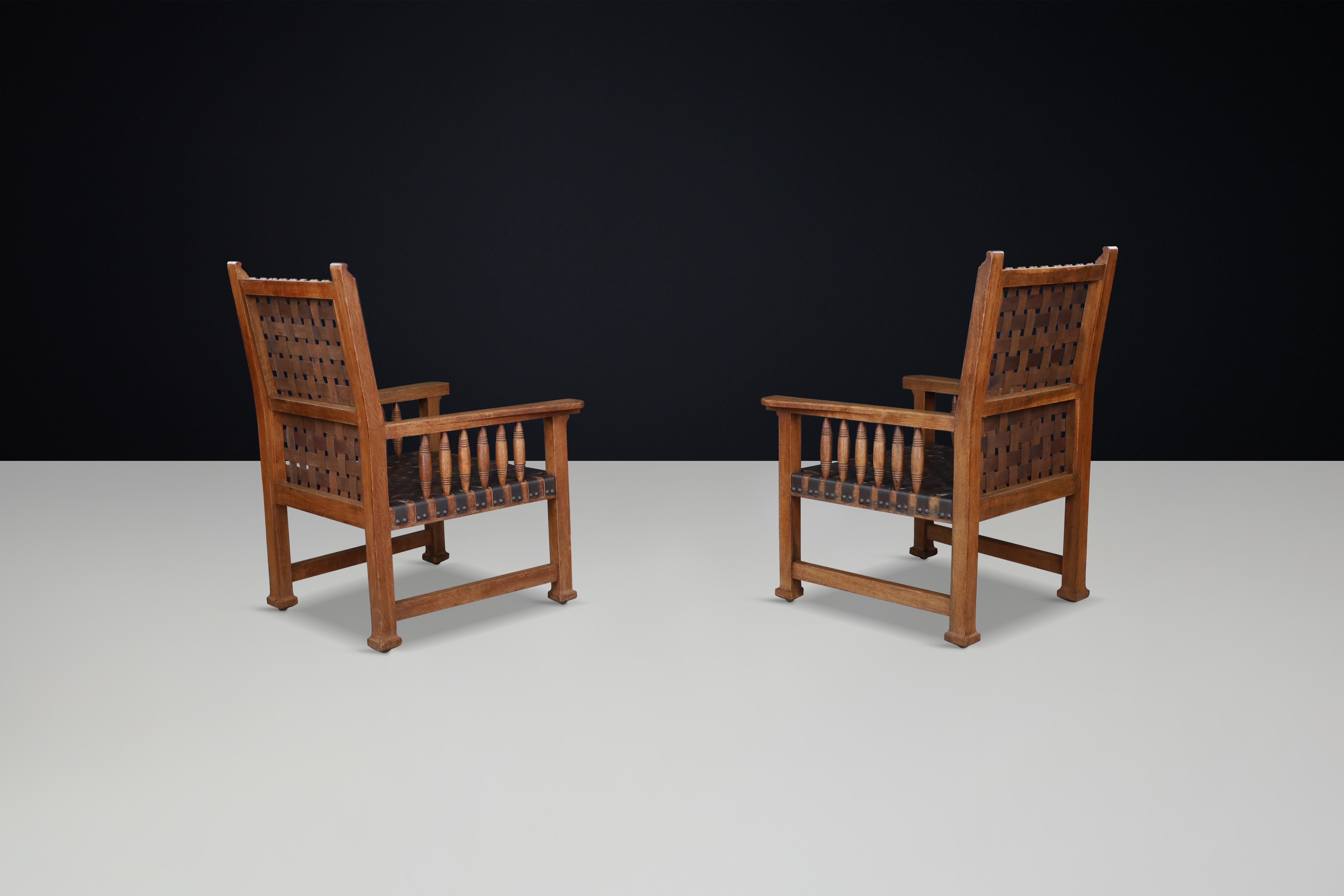 20th Century A pair of leather and oak armchairs from France, 1950s. For Sale