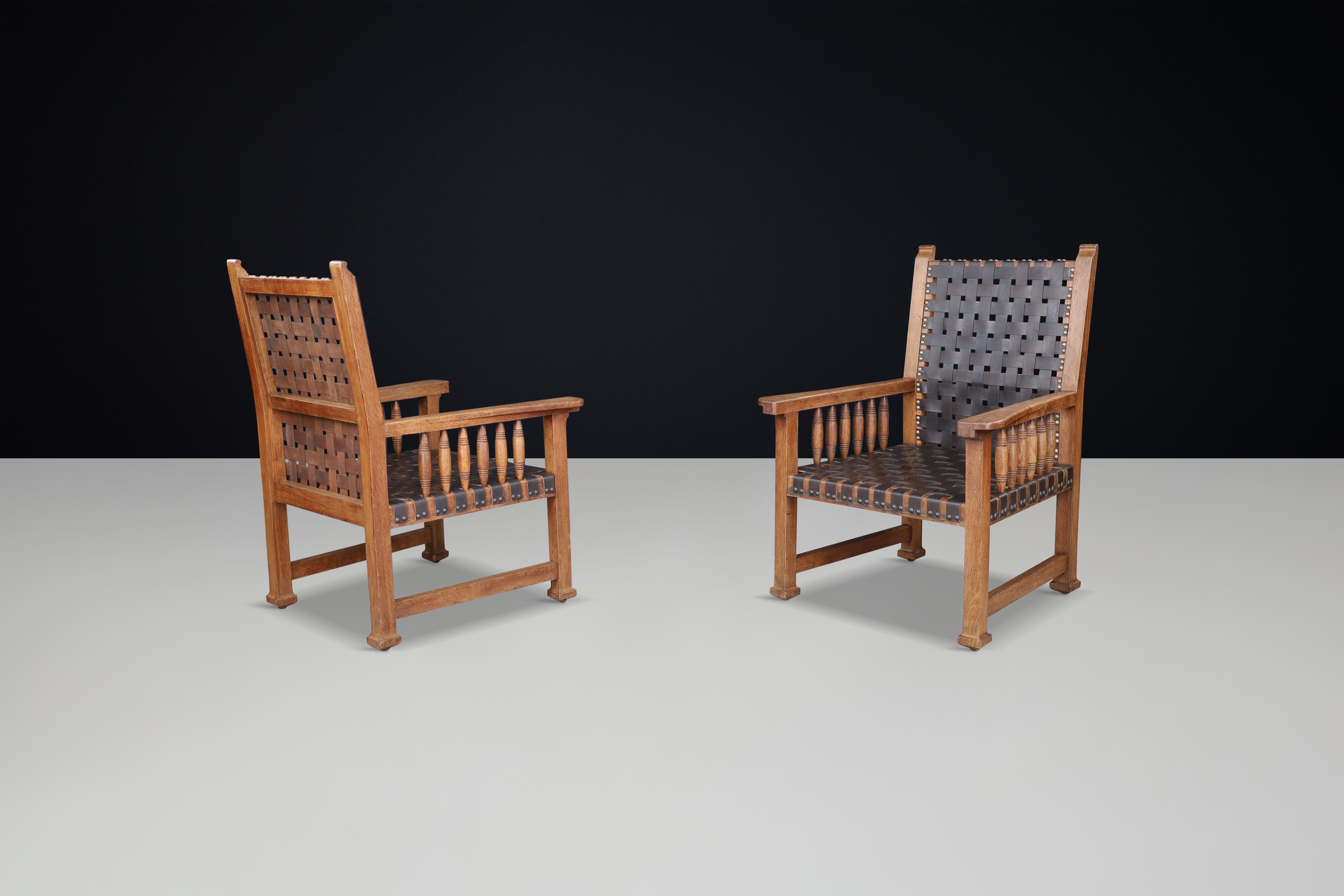 Leather A pair of leather and oak armchairs from France, 1950s. For Sale