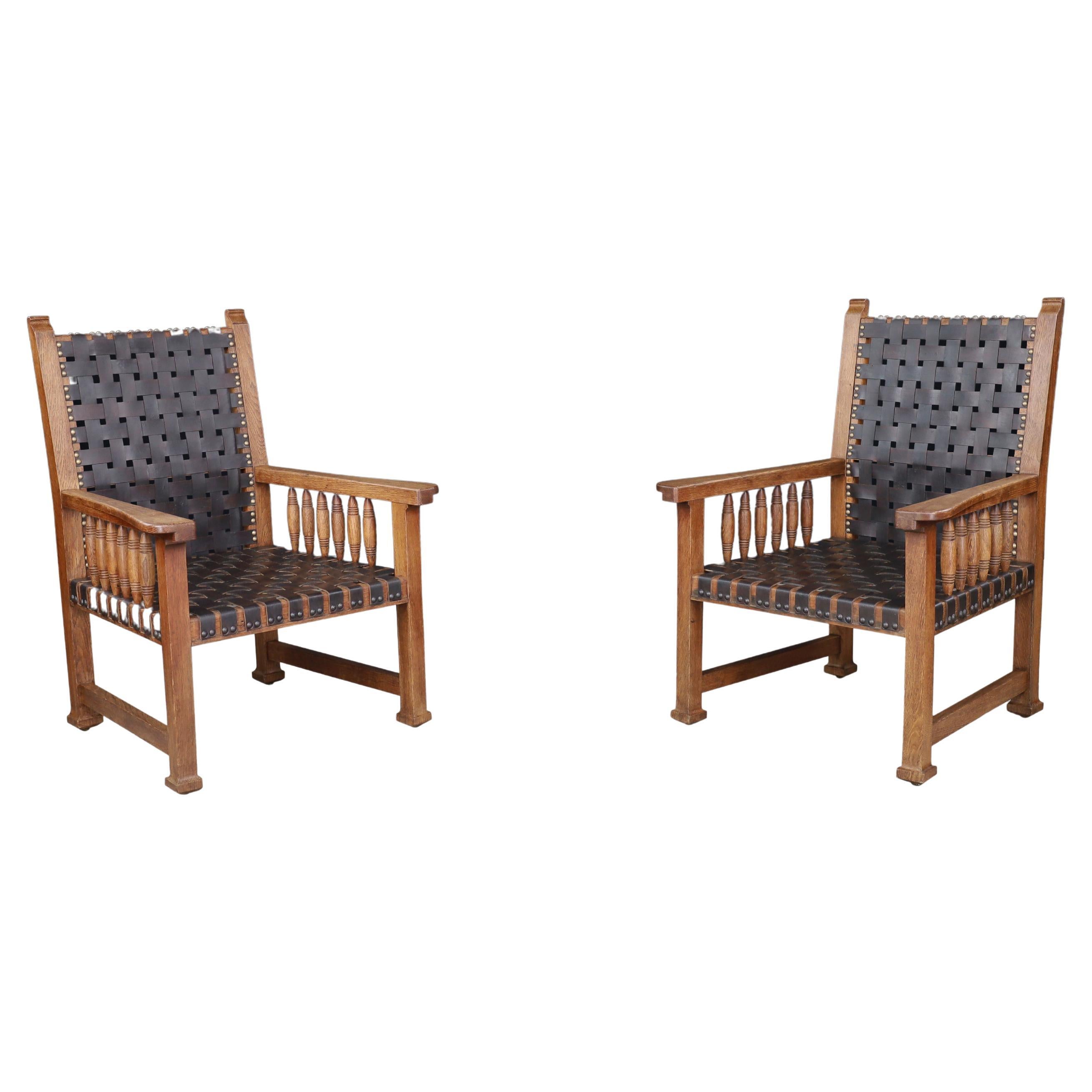 A pair of leather and oak armchairs from France, 1950s.