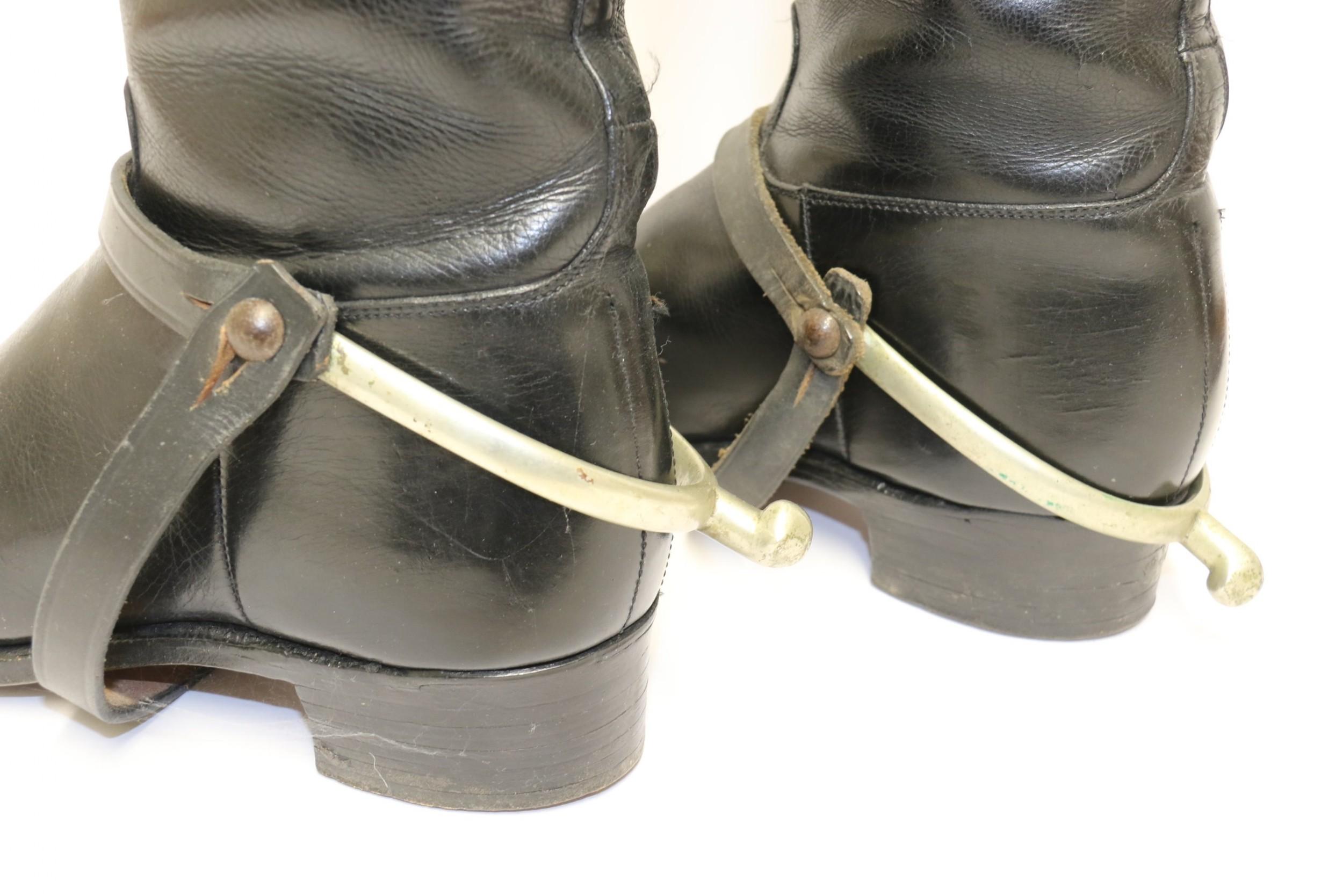 An interesting and decorative group consisting of a high quality pair of black handmade leather ladies riding boots with separate spurs, a brown leather riding crop, a beechwood boot jack and a pair of boot hooks.
The boots are approximately a size