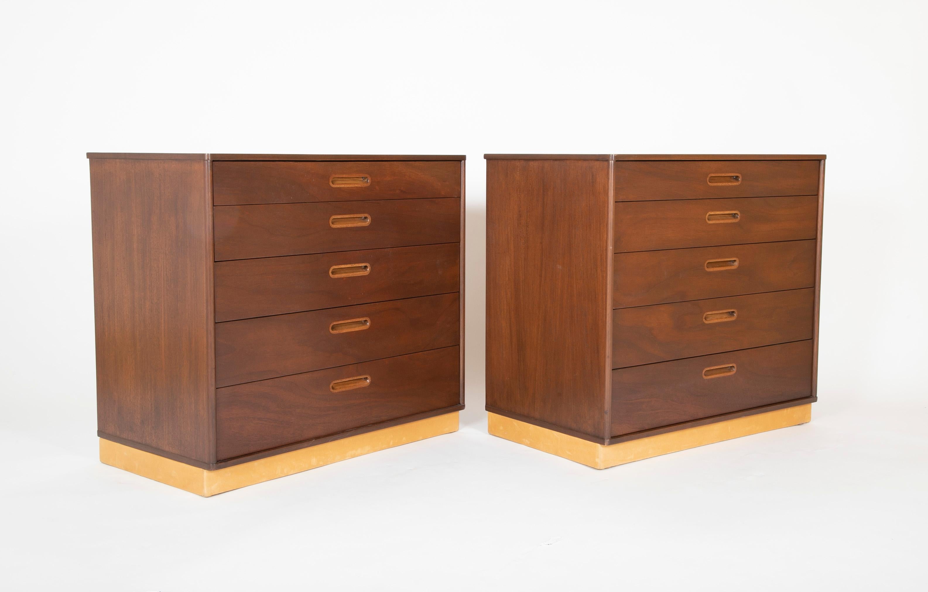 A pair of chests in walnut with leather wrapped baseboards and blond handles. Designed by Edward Wormley for Dunbar, circa 1955.