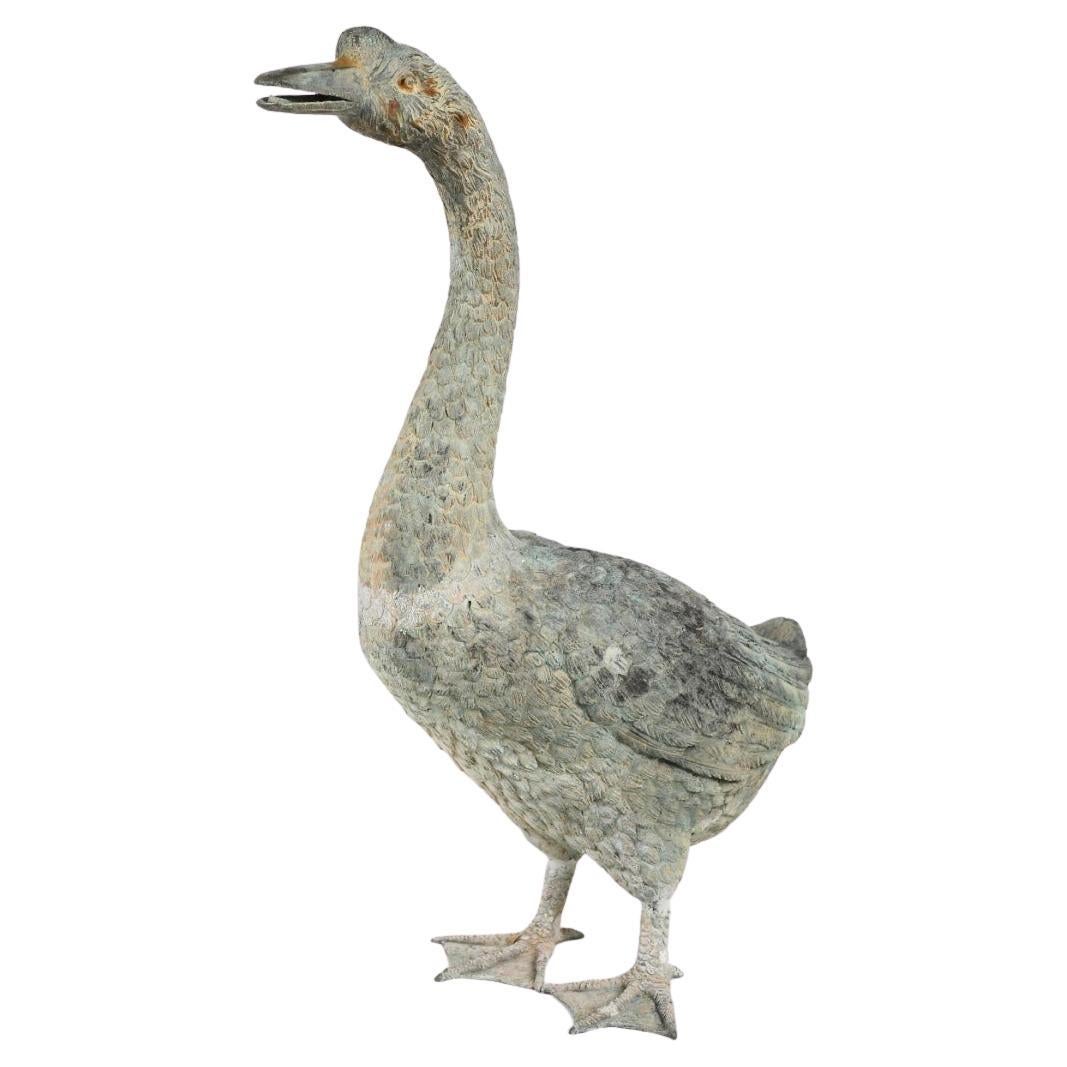 A Pair Of Life Size Bronze Geese. A set of two 20th century French cast bronze life size geese with nice detail, each one realistically cast. Two adult geese with plumage detailed, with lovely worn patina. A wonderful addition to any garden. 