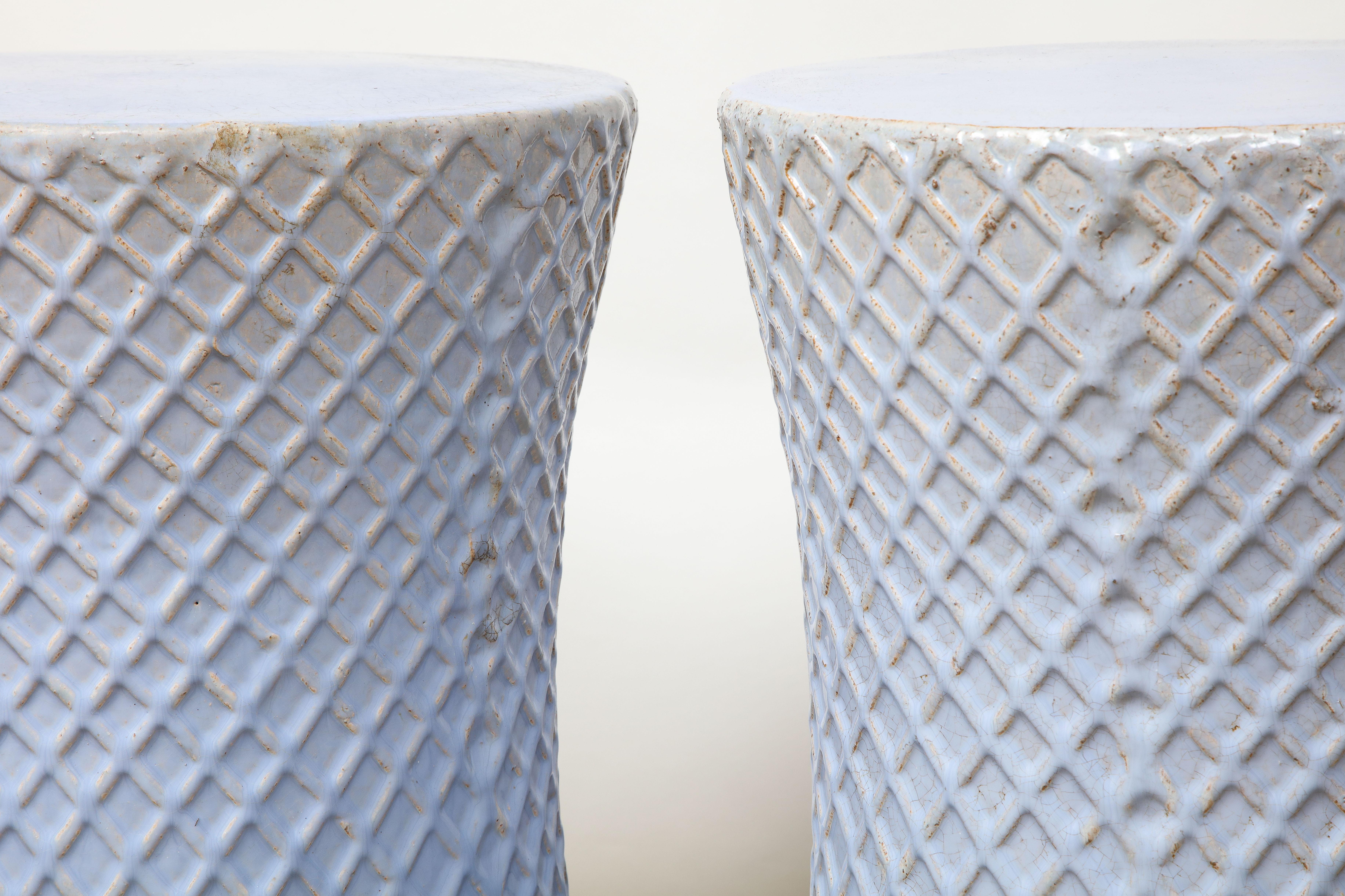 Ceramic garden stools can serve as wonderful accent seats or tables both inside and outdoors. This pair is in a lovely soft blue. While the top is smooth, the side has a textured, diamond pattern. Perfect in the garden or any room in a home.