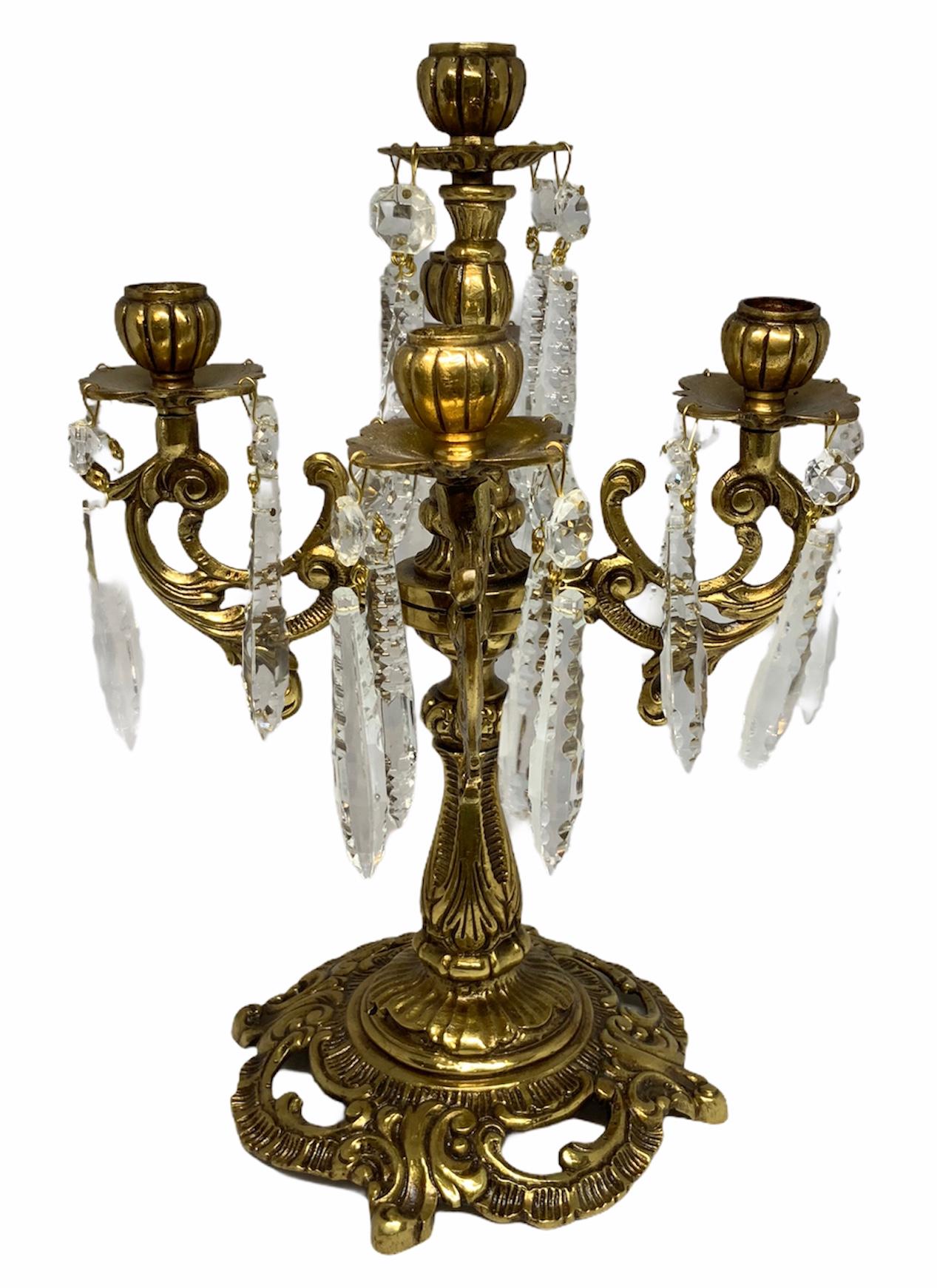 A French Louis XV Rococo candelabra with five ribbed candleholders each one. They are highlighted by a total of forty crystal etched prisms.