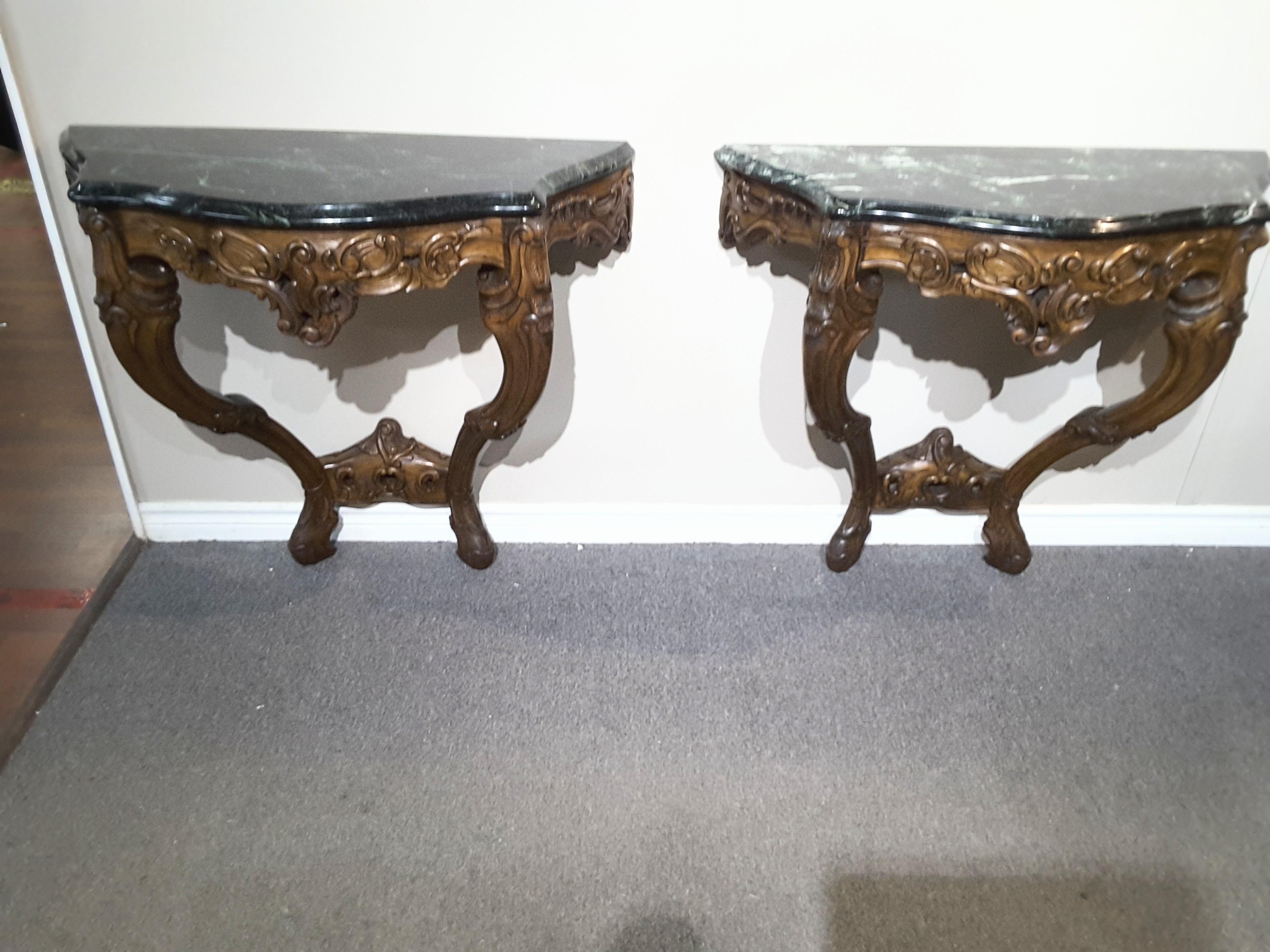A pair of Louis XV style fruitwood console tables with verde green marble top
19th century,

The Verde indio marble top on a foliate and c-scroll carved base with cabriole legs jointed by a conforming stretcher.

Measuring,
33 3/4