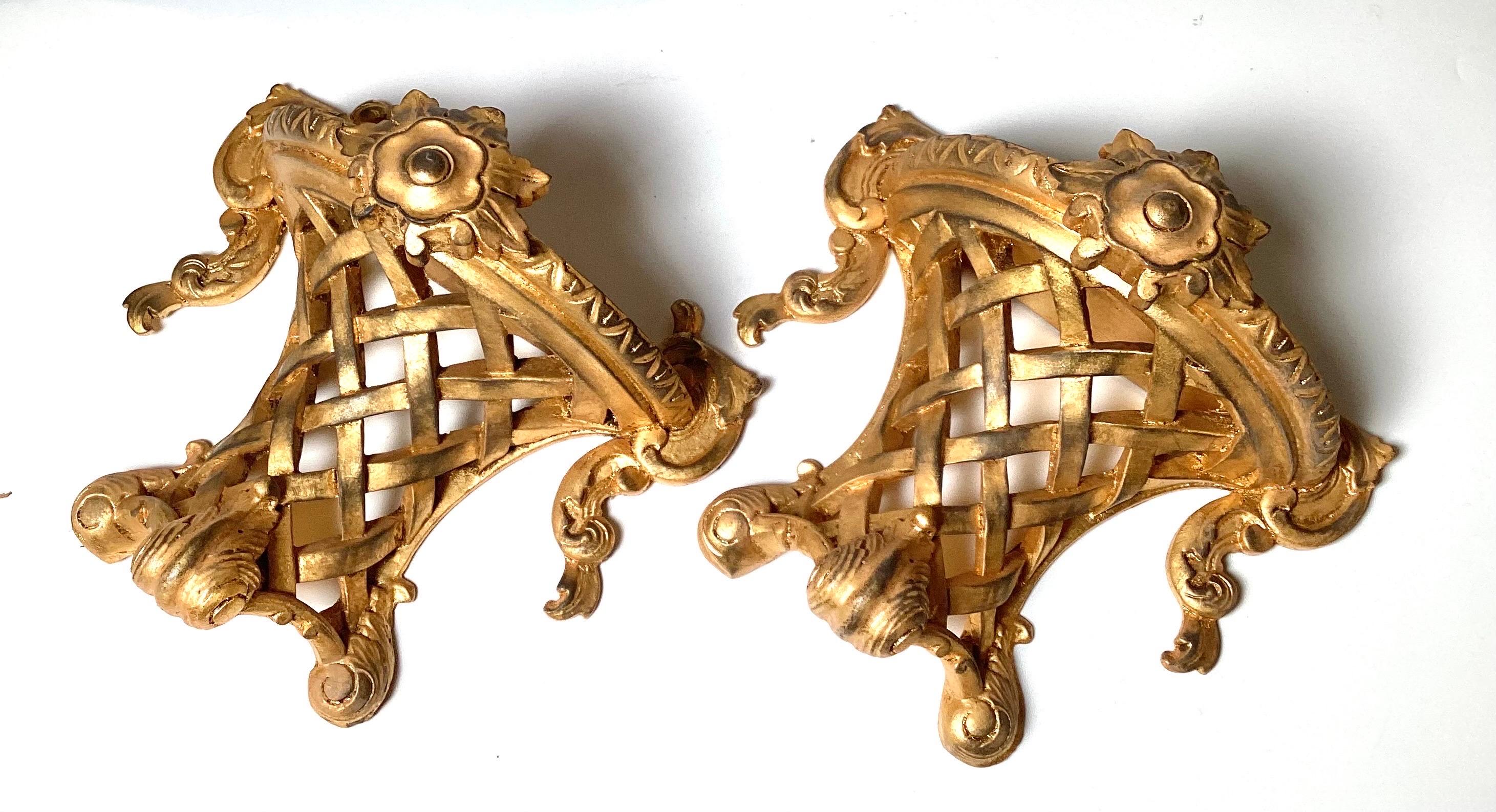 An unusual pair of Italian made gilt wood wall shelves.  The Louis XV style with a lattice work center with Demilune top and scrolling details. 11 inches wide, 10.5 inches tall, 6 inches deep. 