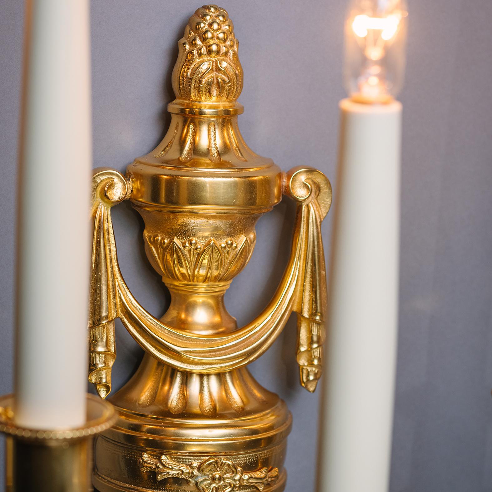 Paire d'appliques murales à cinq lumières en bronze doré de style Louis XVI. 

Chacune d'entre elles est ornée d'un plat arrière en forme de carquois surmonté d'un fleuron en forme d'urne classique. Délivrance de cinq branches portant la lettre 