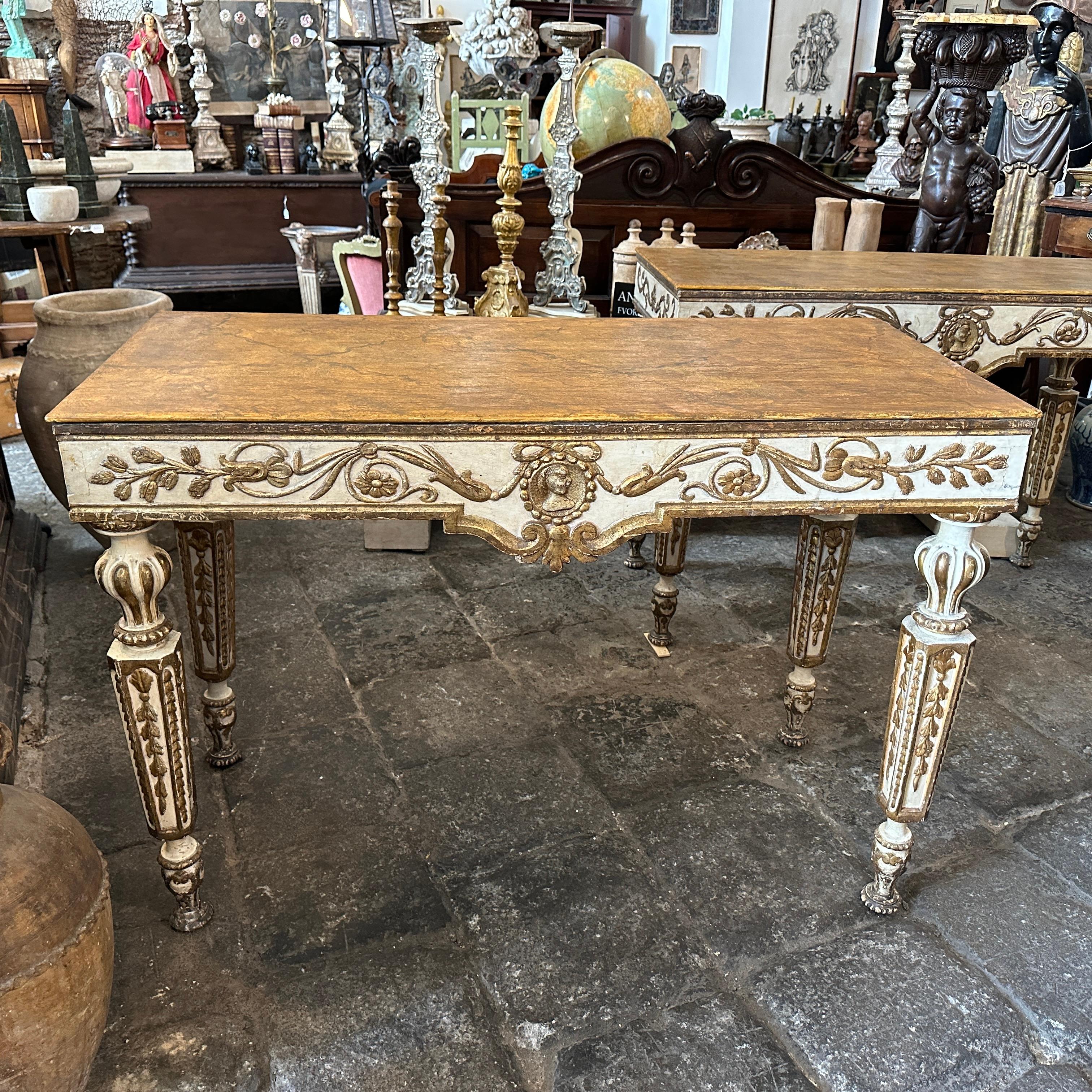 These two italian consoles are exquisite pieces of furniture, echoing the elegance and sophistication characteristic of the Louis XVI style, they are in original condition, ivory and lacquered wood has normal signs of use and age, fake marble