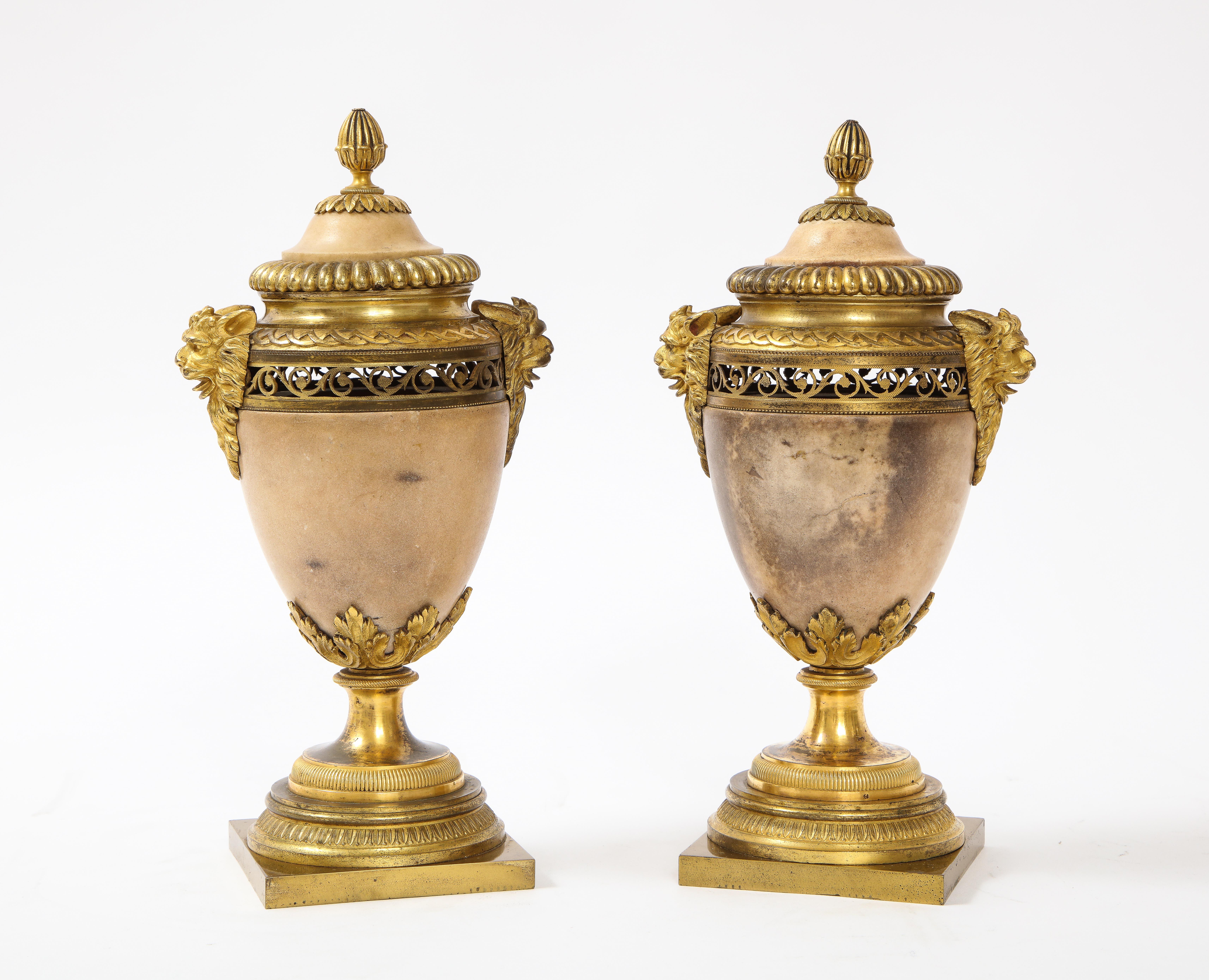 A fabulous pair of Louis XVI Northern European neoclassical ormolu mounted marble potpourris. The body of each is hand-carved from a very fine quality peach-ish-colored marble. Each side is flanked with exceptionally cast, hand-chassed, and