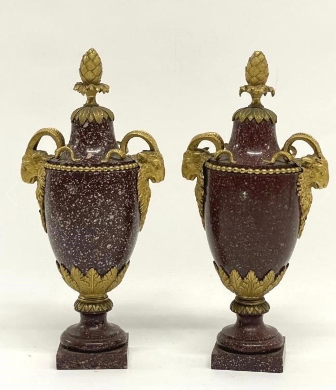 The mounts are similar to those by Gouthière. The one vase having more speckling of white in the porphyry than the other.