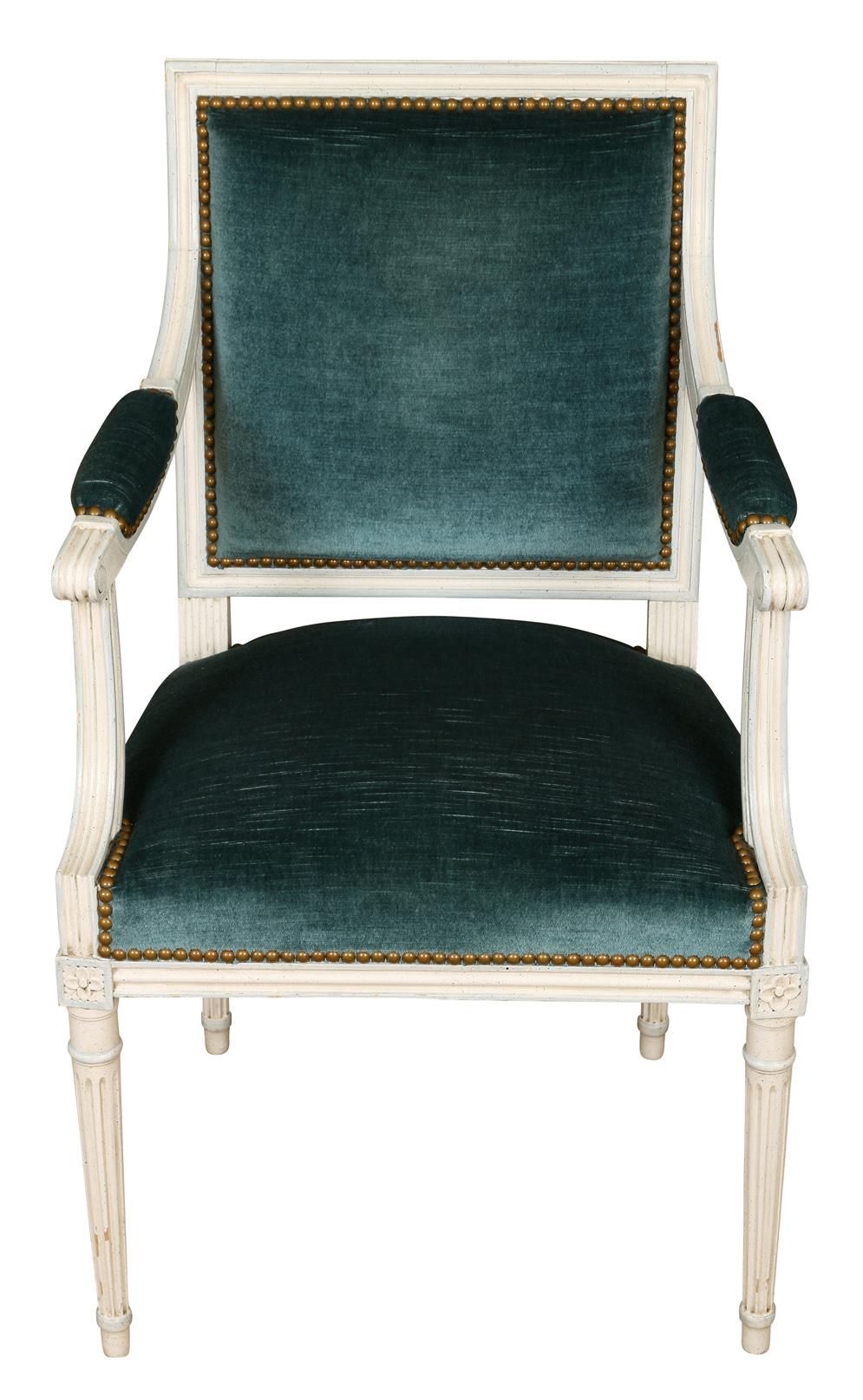 We love these Louis XVI style arm chairs for their clean lines and quiet elegance. These chairs, painted in white with a soft gray accents, feature many details characteristic of the Louis XVI style-- a square back, fluted tapered legs and a carved