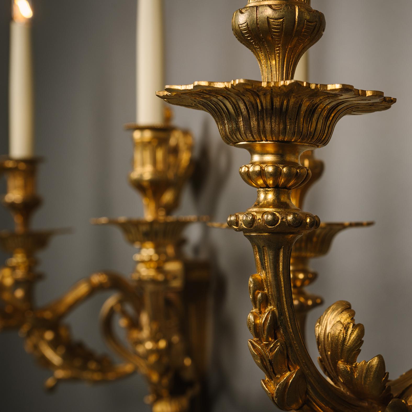 Doré Paire d'appliques murales à trois lumières de style Louis XVI en bronze doré en vente