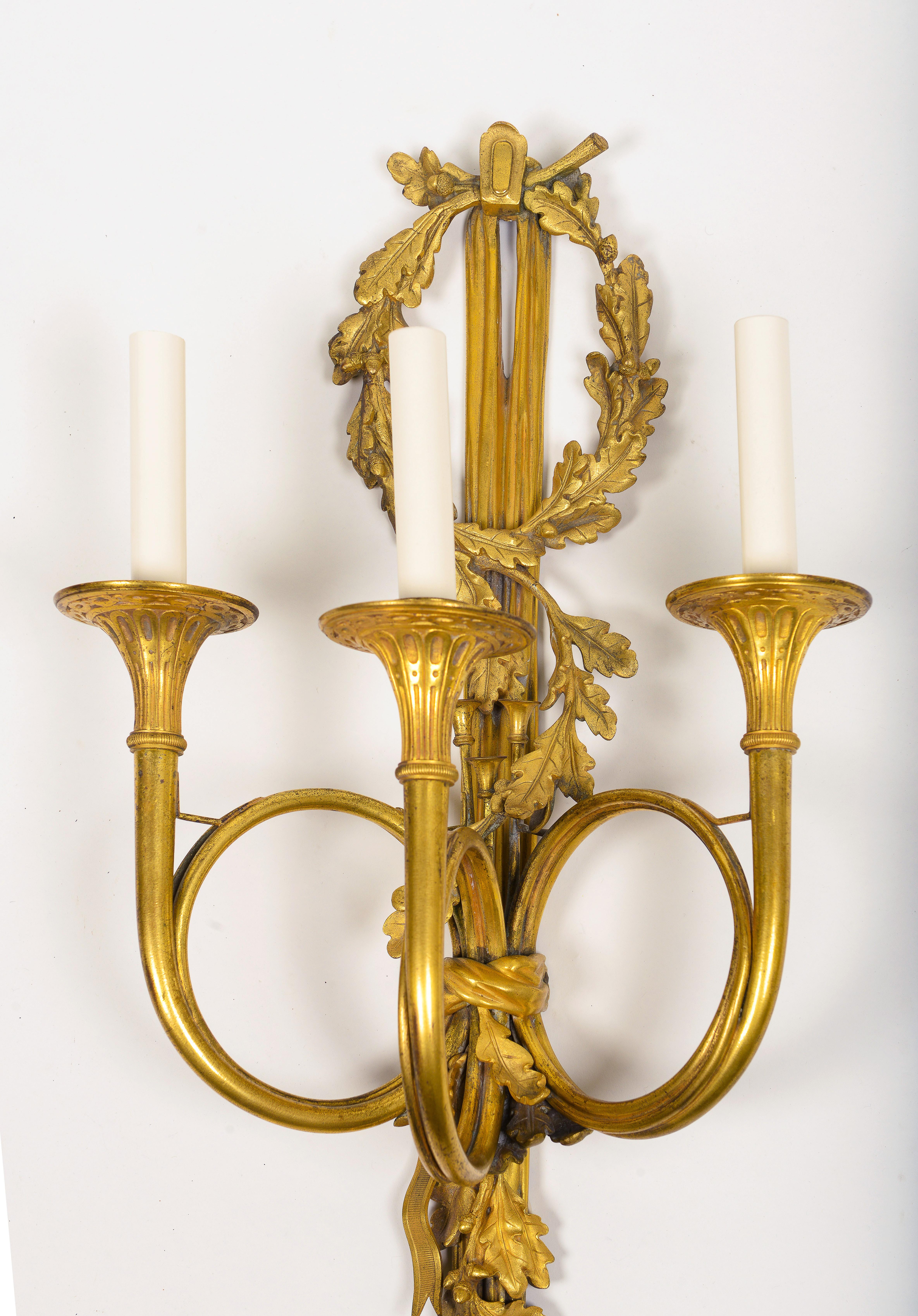 Zwei dreiflammige Wandleuchter aus vergoldeter Bronze im Louis-XVI.-Stil (Vergoldet) im Angebot