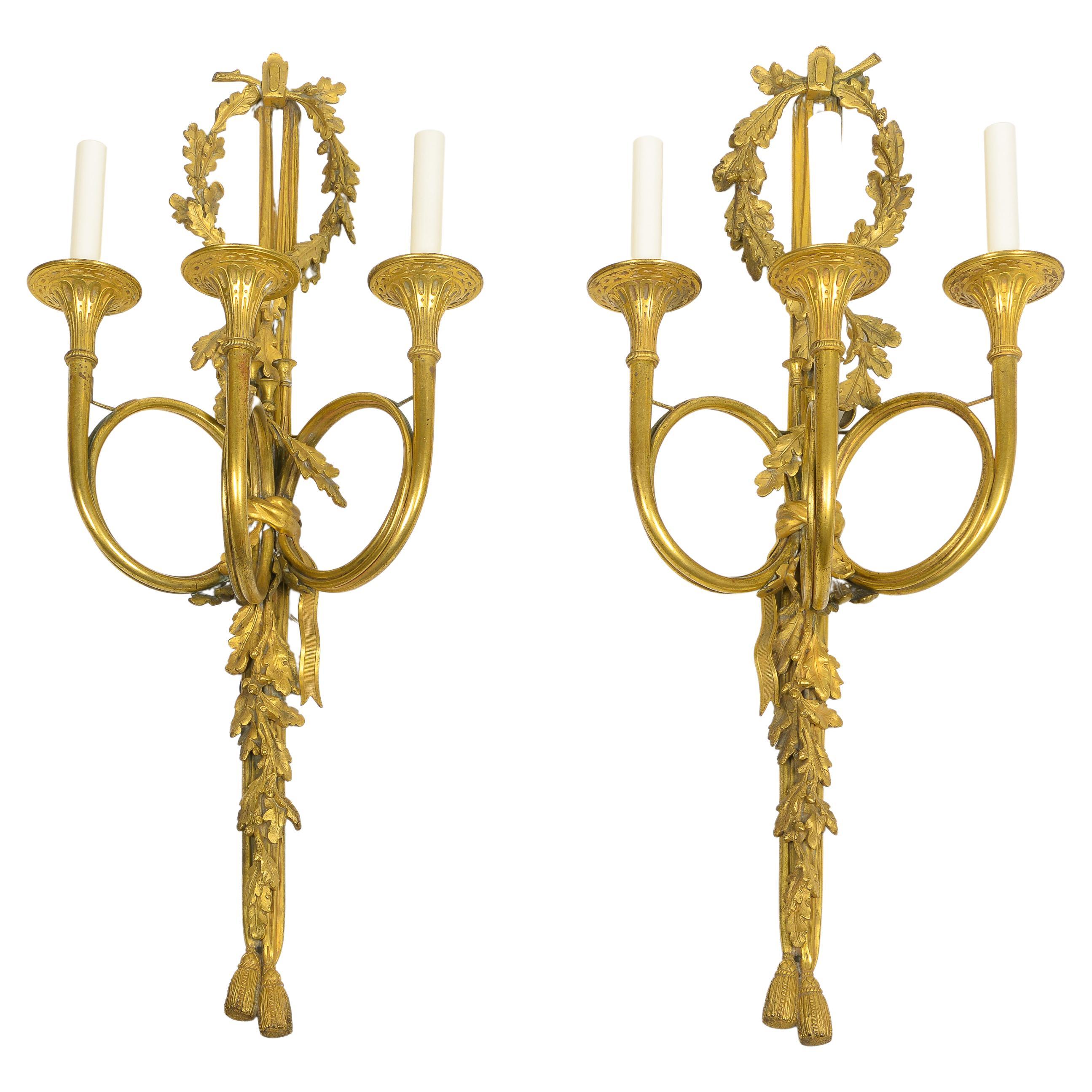 Zwei dreiflammige Wandleuchter aus vergoldeter Bronze im Louis-XVI.-Stil im Angebot