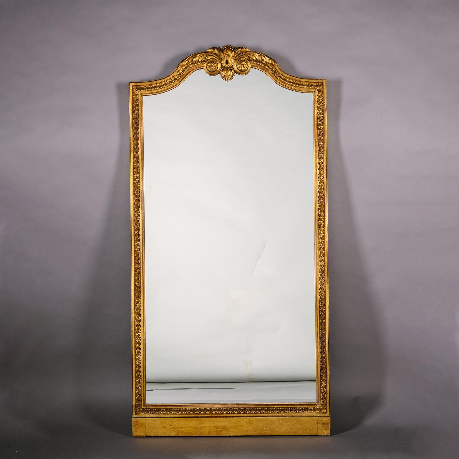 Paire de miroirs en bois doré sculpté de style Louis XVI. 

Chaque miroir possède une plaque de miroir arquée et un cadre correspondant sculpté d'un décor de feuilles mortes et d'un fronton arqué centré par une volute d'acanthe frondeuse. 

France,