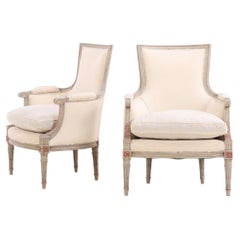 Pareja de sillas Bergere estilo Luis XVI pintadas de gris y parcialmente doradas, C. 1940.