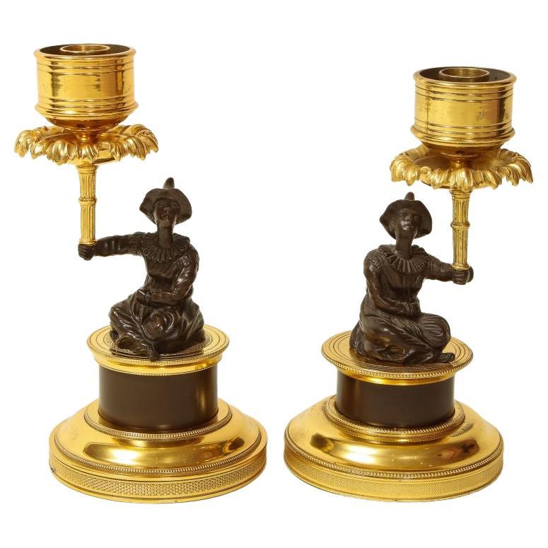 Pair of Louis XVI Style Harlequin Figural Bronze and Gilt-Bronze Candlesticks