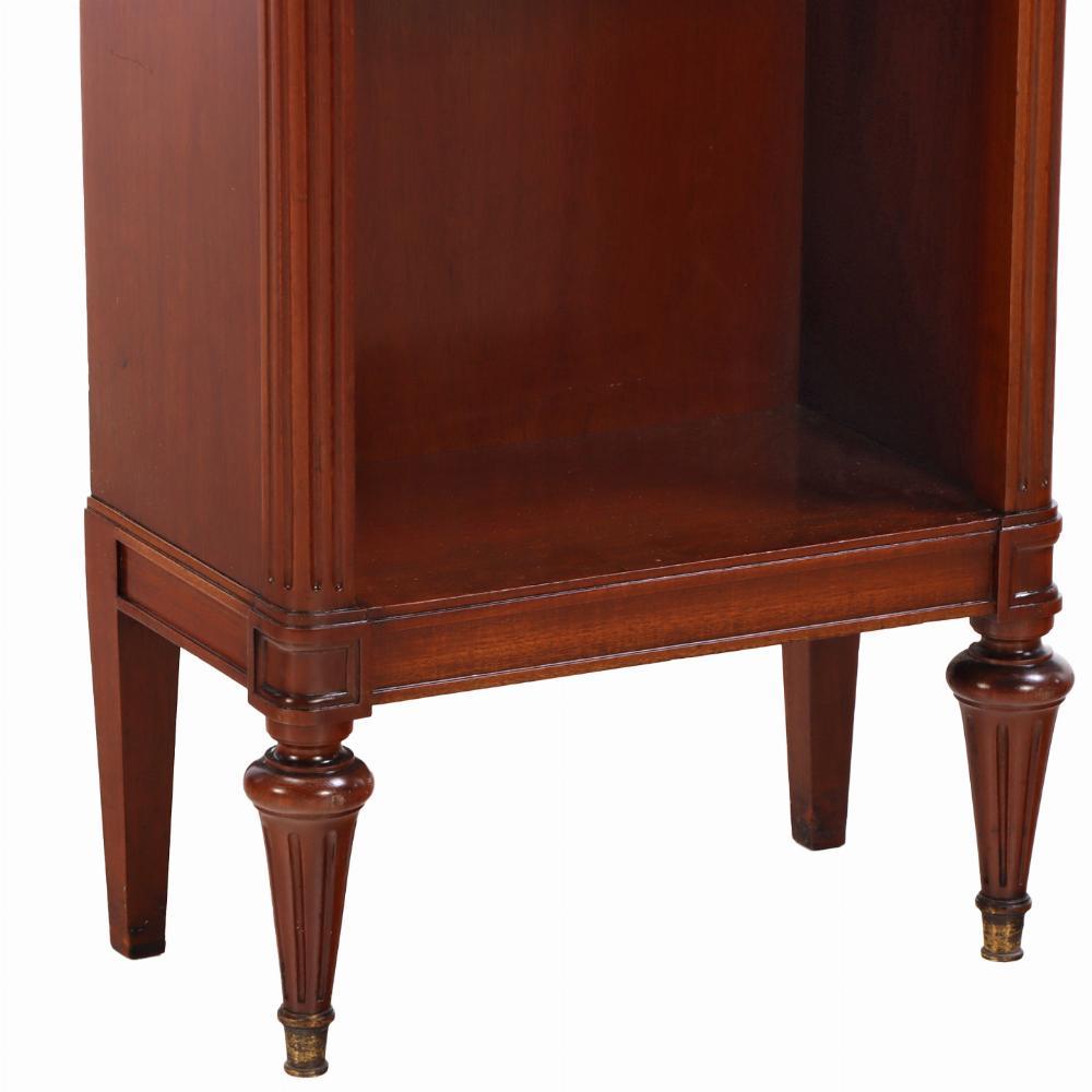 Raffinata coppia di librerie in mogano in stile Luigi XVI, 1920 circa, ciascuna sormontata da una superficie in marmo riccamente venata e incorniciata da una delicata galleria in ottone traforato su un unico cassetto e tre ripiani. Realizzate con le