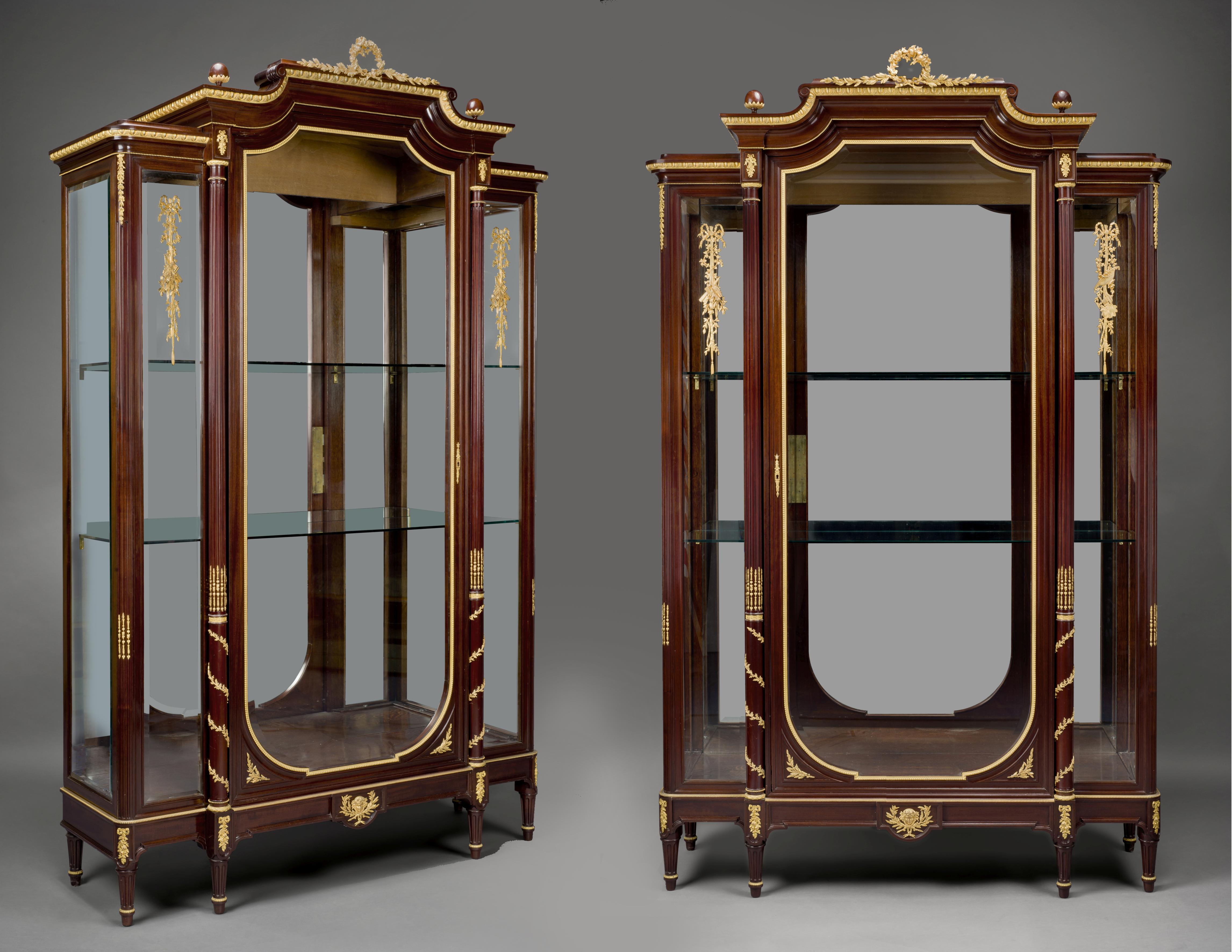 An impressive pair of Louis XVI style gilt bronze mounted mahogany vitrines by François Linke. 

French, circa 1890.

Signed to the reverse of the bronze mounts ‘LINKE’.

Each vitrine has a spreading pediment centred to the top by a